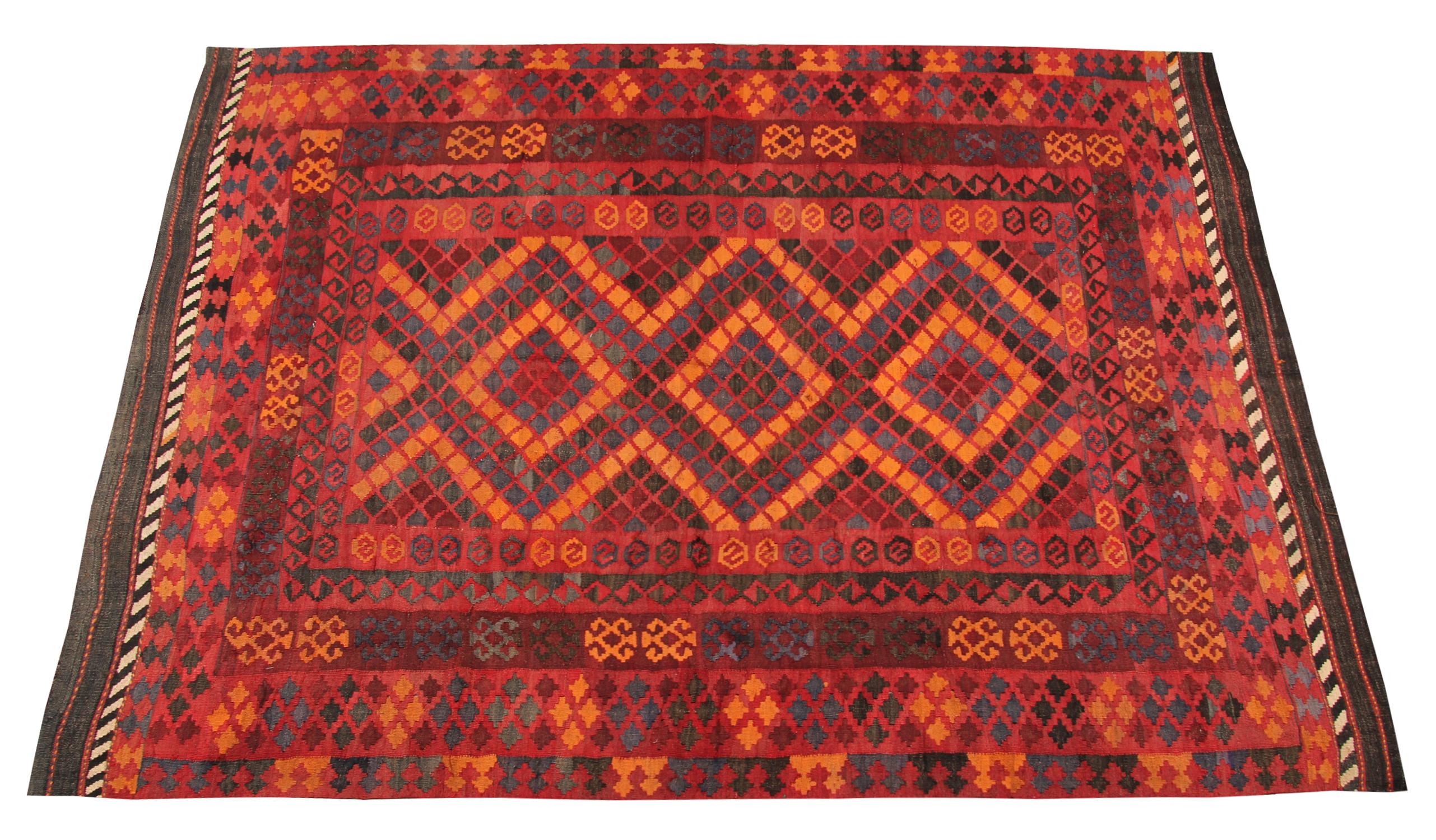 This orange-red rug is a Turkish carpet rug has woven by very skilled weavers in Turkey, who used the highest quality wool and cotton. The flat-weave rug has dark and light red, blue and dark brown colors. The red and blue background of this