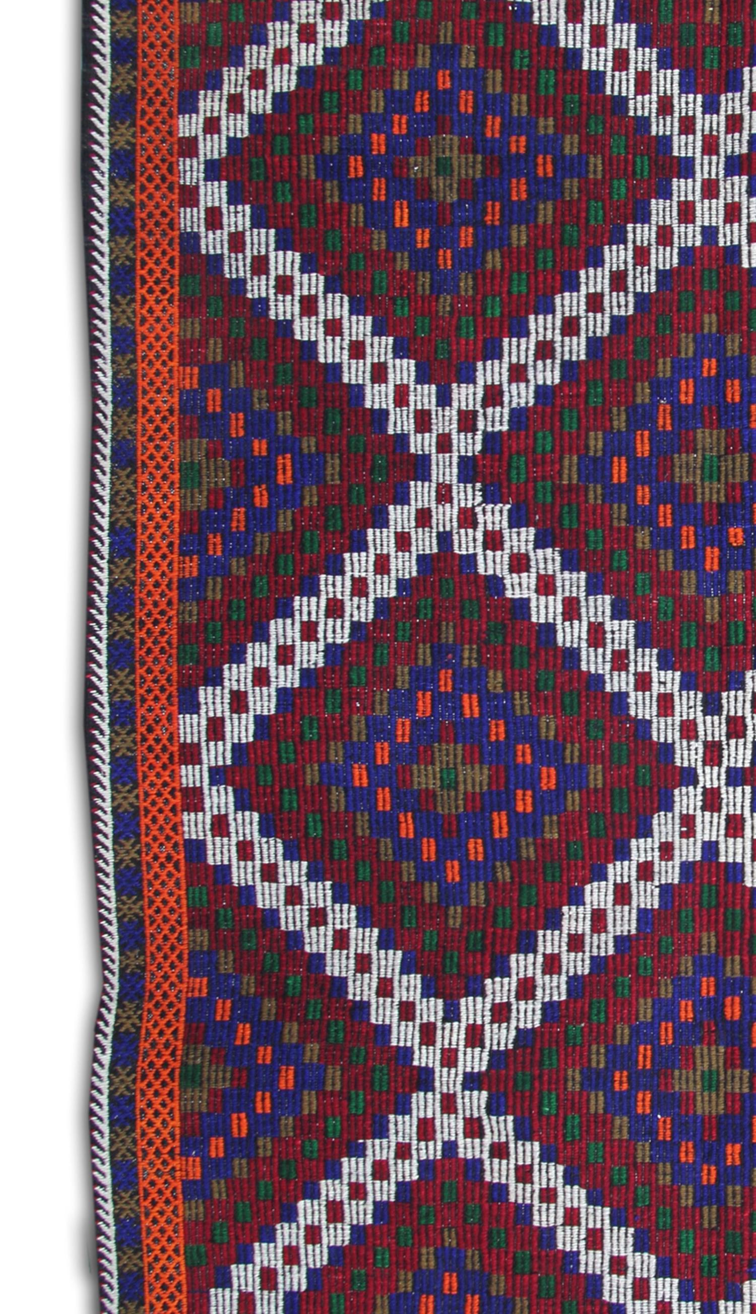 This vintage Turkish Kilim rug features a vibrant red background with three central medallions woven in decorative blue and brown accents. 
 These flat-woven rugs are recognised word-wide due to their stunning colour and pattern combination. The