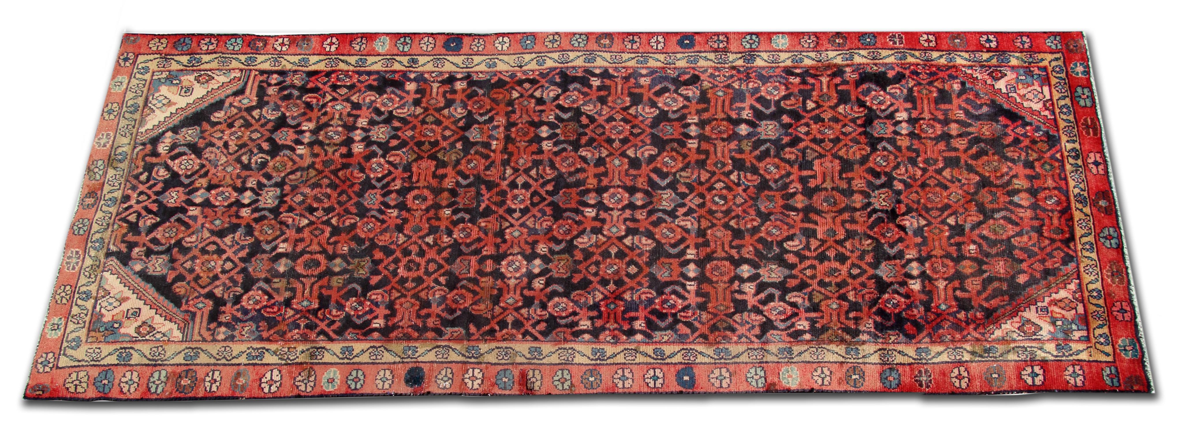 Are you in the market for a new vintage runner rug? Then look no further this fine handwoven wool runner rug has been woven with a bold central repeating pattern design in accents of pink and red on deep blue background. This is then framed by a
