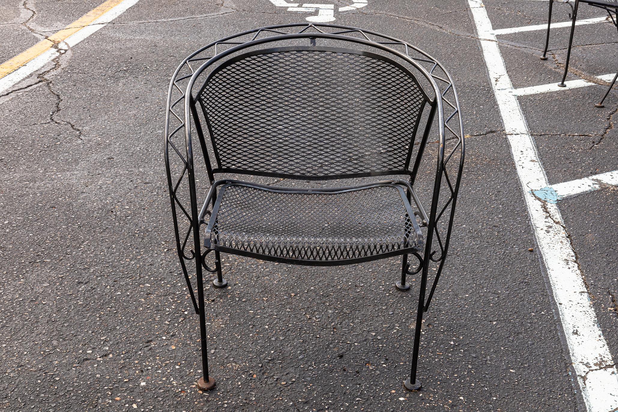 A Russell Woodard wrought iron patio set with table and 4 chairs. A fantastic vintage circa 1940s patio set from Woodard Furniture. This whole set features wrought iron construction, black coloring, and high quality design. This whole set is in very