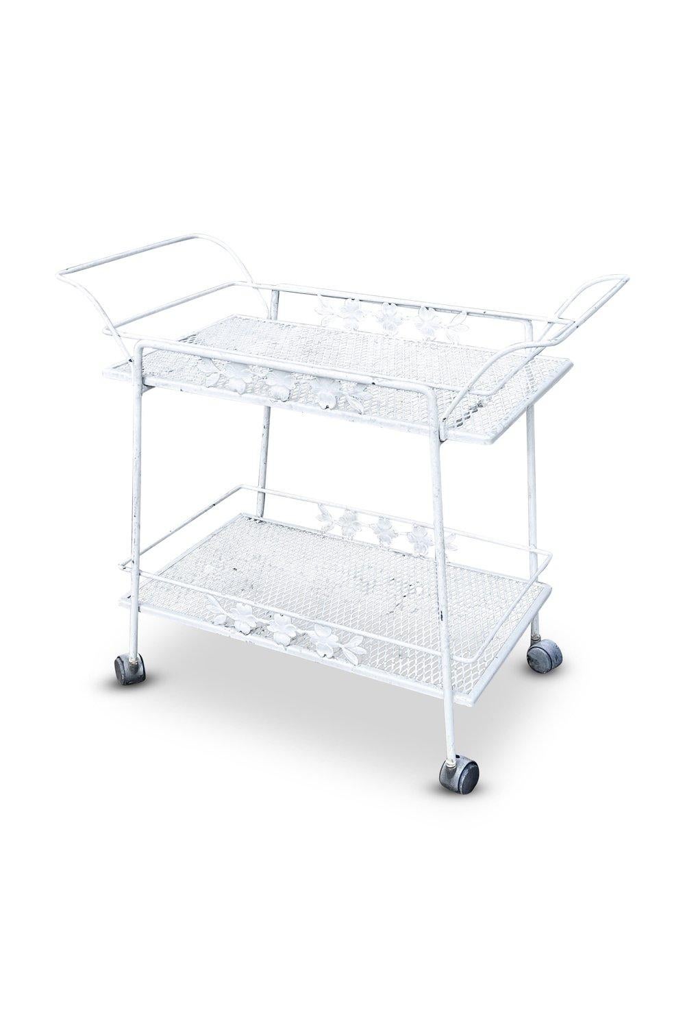The vintage Russell Woodard wrought iron bar cart is a mid-century classic, designed in the 1950s and 1960s by Russell Woodard, a renowned furniture designer. Made of durable wrought iron, it features elegant curves and intricate detailing,