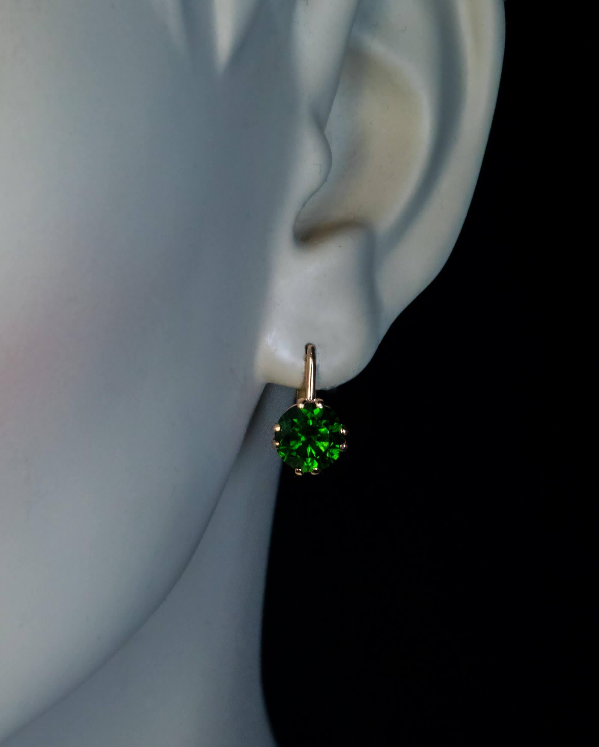 circa 1970s

These Soviet era 14K gold earrings feature two perfectly matched brilliant cut 2.23 ct and 2.23 ct Russian demantoids of dark green color. Both demantoids have fine “horsetail” inclusions which are typical for demantoids from the Ural