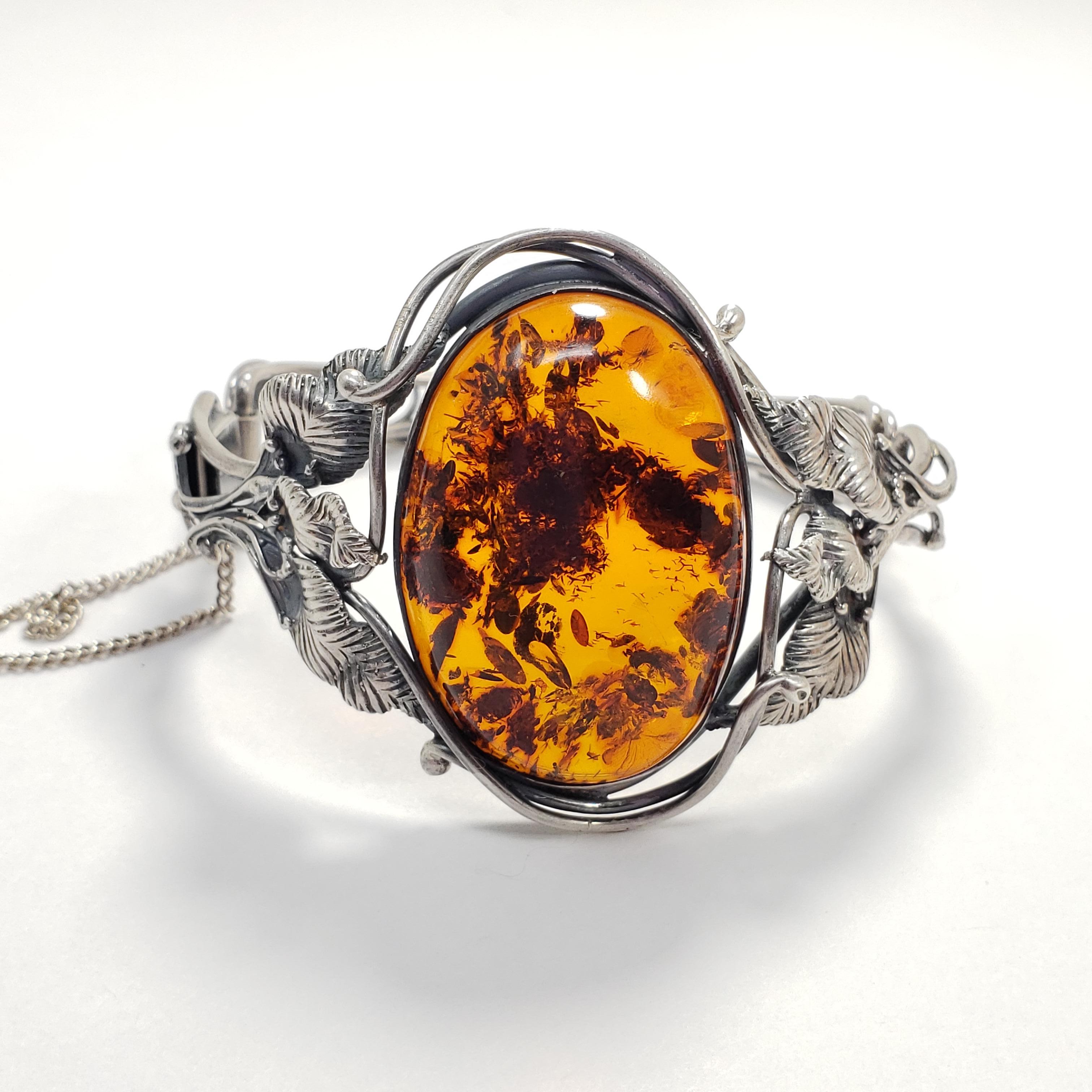 Exquisite Russian bracelet, featuring a genuine Baltic amber cabochon on a stylish sterling silver cuff.

Inner diameter at widest part: 2.25 inches
Inner circumference: 6.5 inches