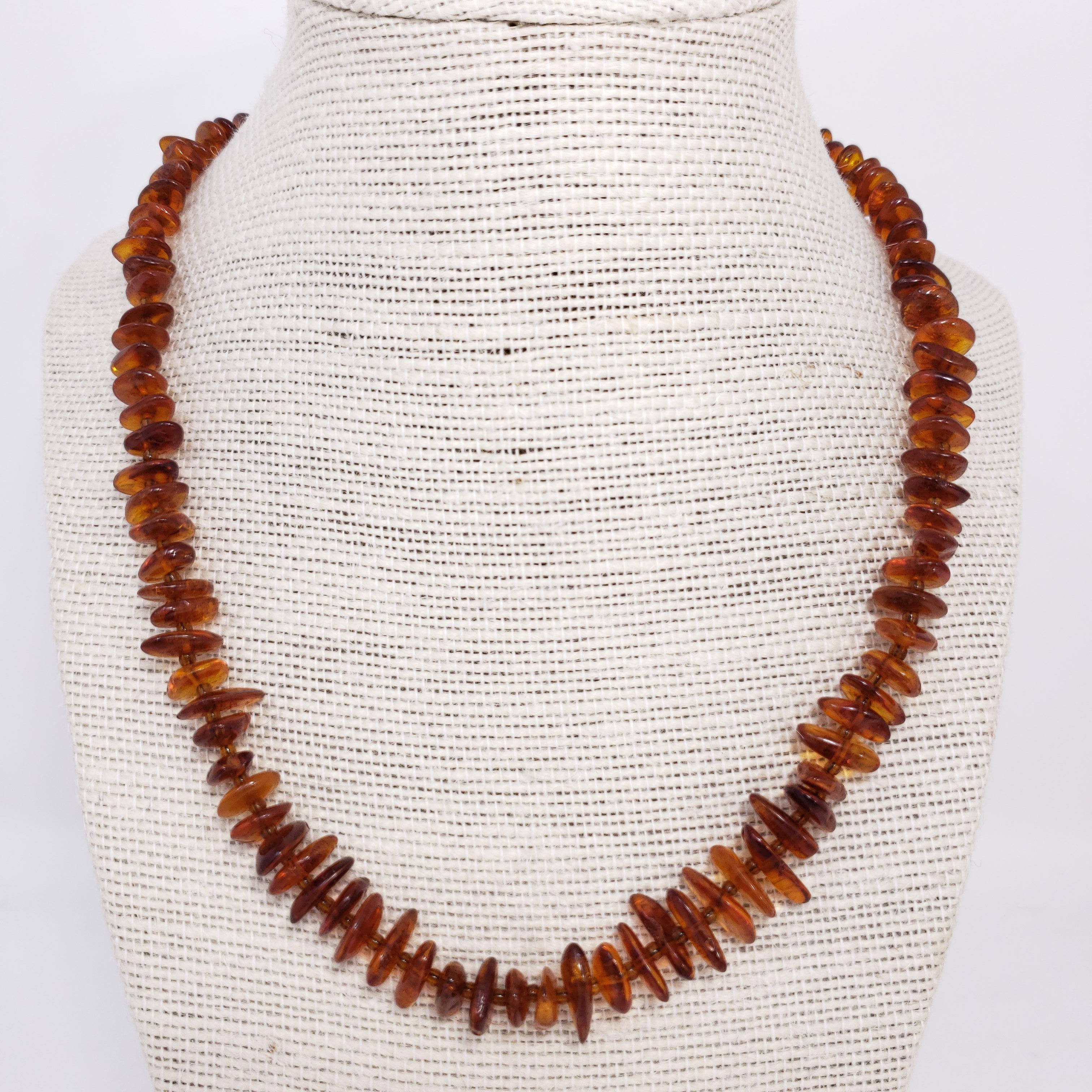 Exquisite Russian necklace, featuring flat Baltic amber beads in a gorgeous dark orange tone, with smaller alternating spacer beads.

Circa mid 20th century.
