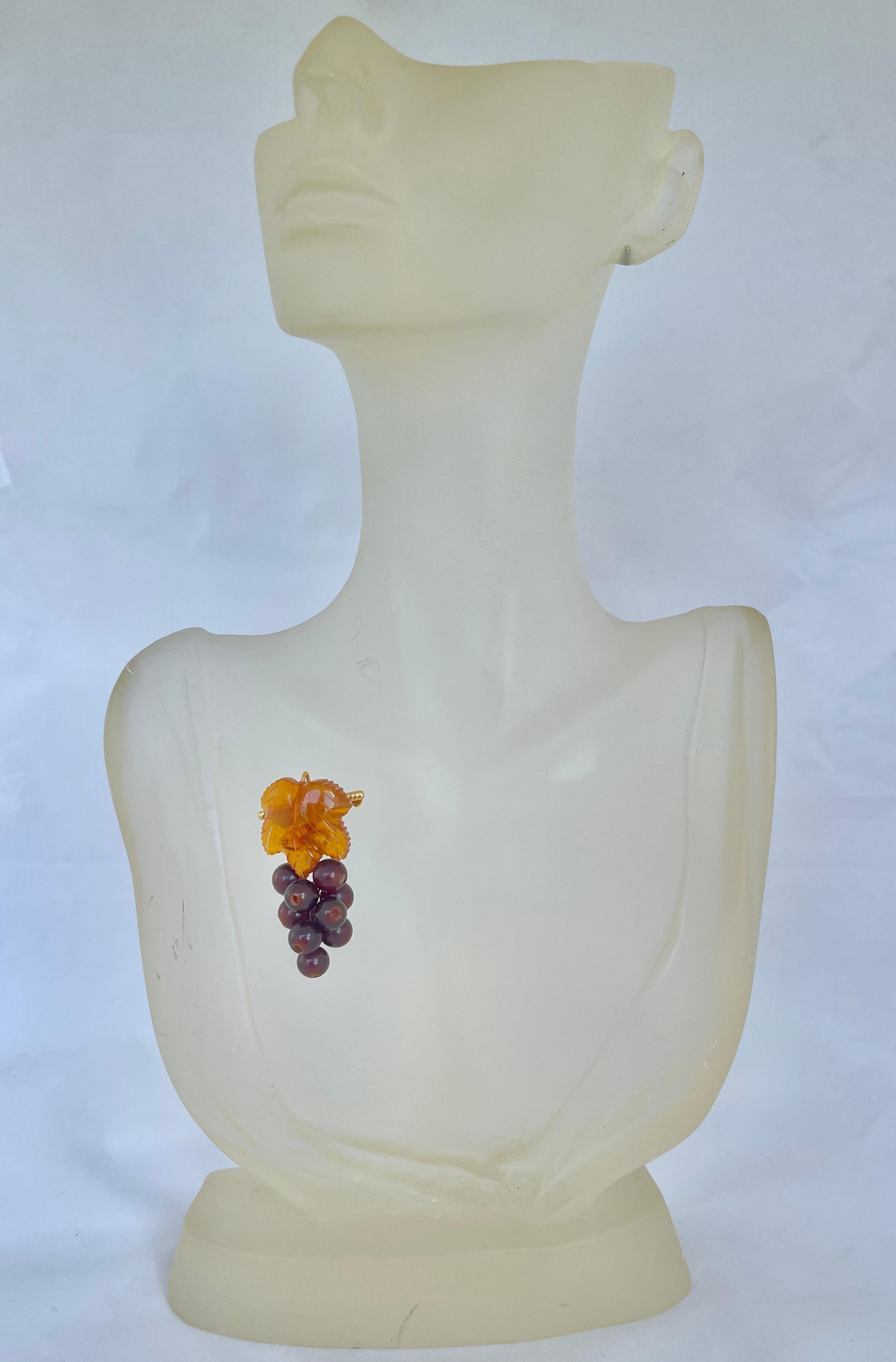 This is a beautiful, hand crafted vintage brooch from Russia with hallmarks.

The piece is crafted from genuine Baltic Amber with natural inclusions.  It features a yellowish-brown, carved leaf with a bunch of darker brown grapes that articulate