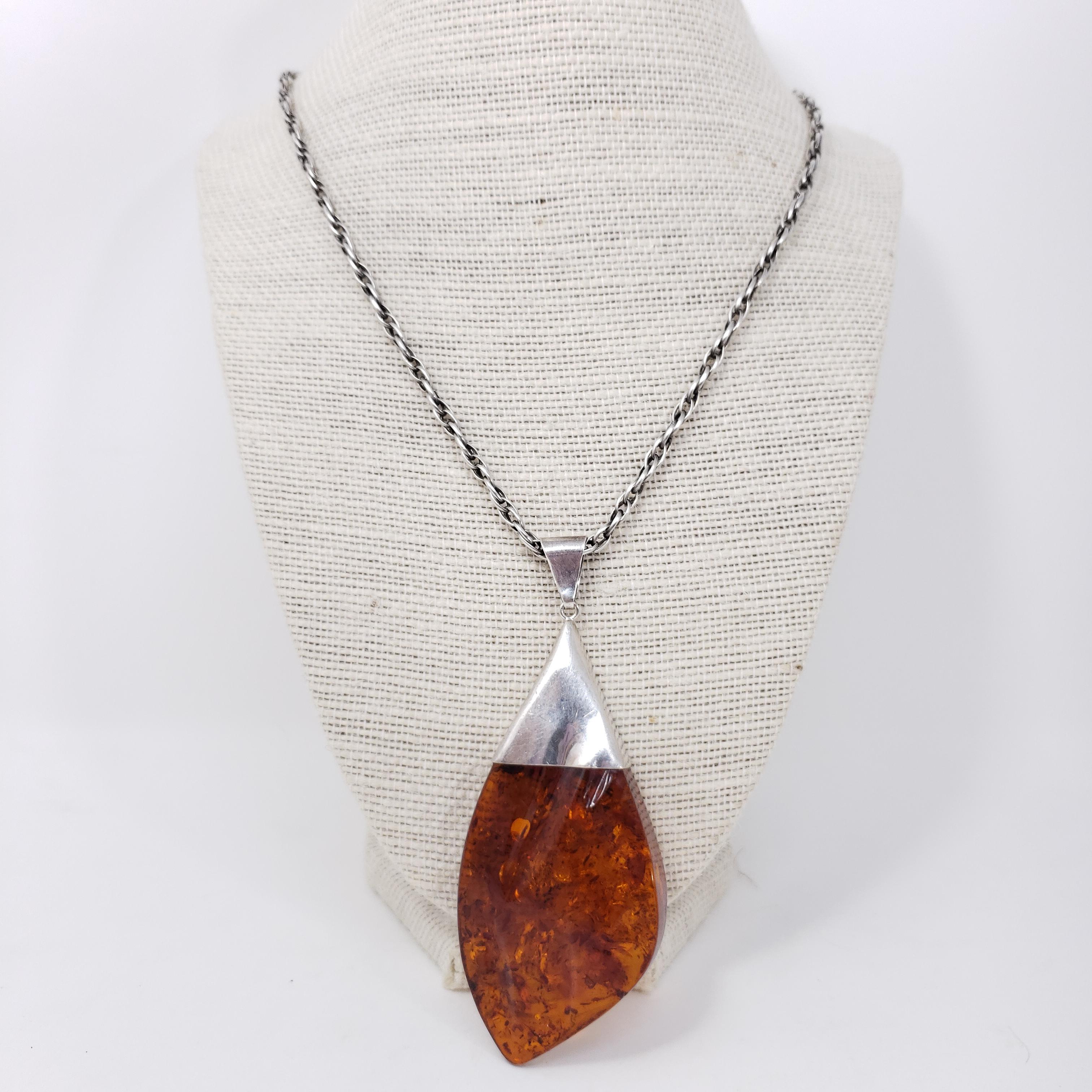 Exquisite Russian pendant, featuring a beautifully-carved genuine Baltic amber cabochon on a stylish silver chain chain.

Sterling Silver.

Necklace length: 25 inches / 63.5 cm
Pendant dimensions: 3.25 x 1.5 in / 8 x 4 cm