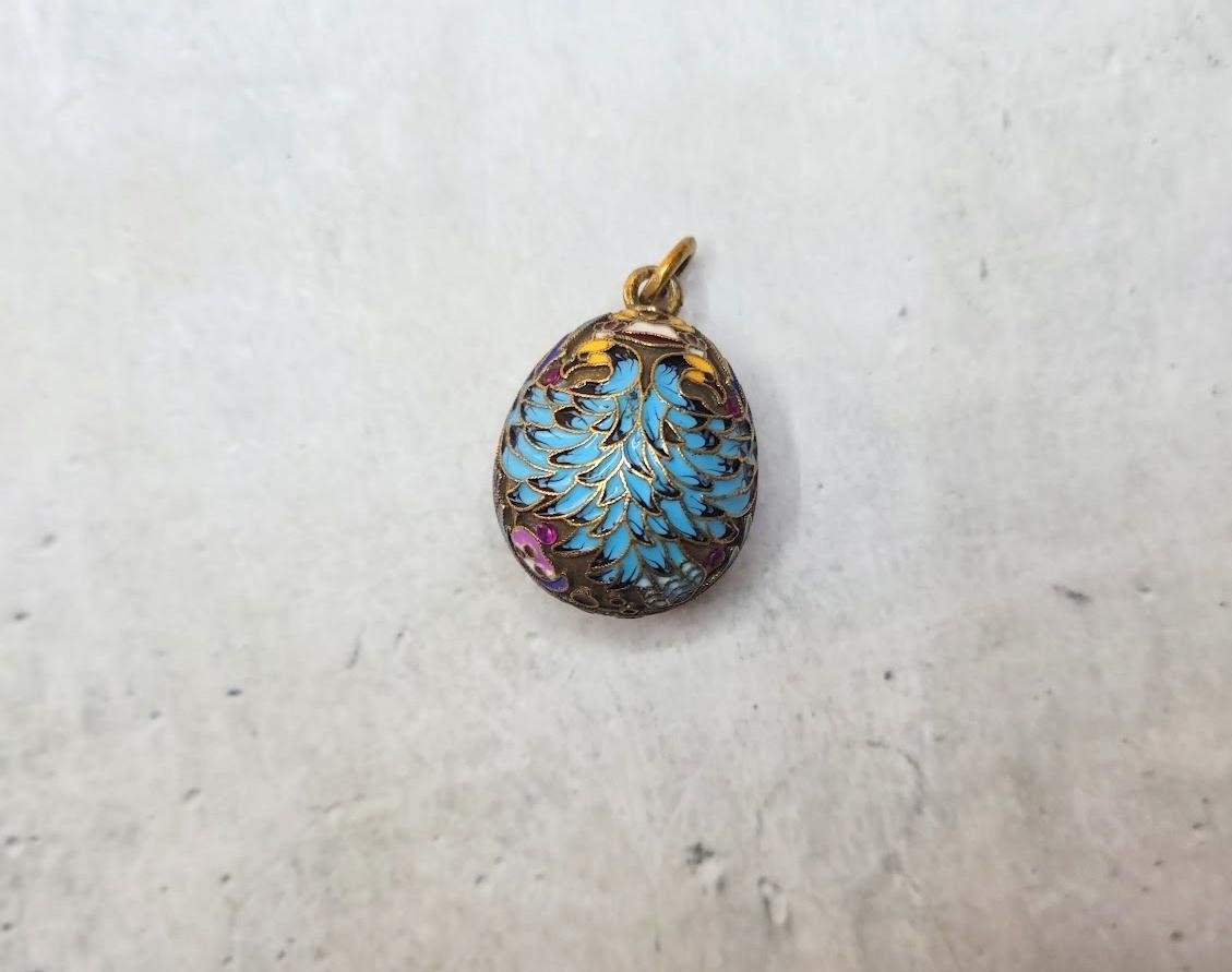 This exquisite vintage Russian Soviet gilded silver egg pendant showcases stunning turquoise cloisonné enamel eagle motifs adorned with granulated accents reminiscent of Medieval Russian craftsmanship. It boasts eight 1.3mm natural faceted rubies,