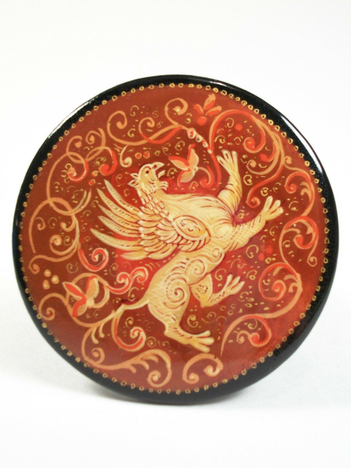 Broche vintage en laque Fedoskino russe - peinture à la main de haute qualité représentant un lion mythique entouré de volutes - entourée d'une bordure noire avec de fins détails dorés - faite à la main - non signée - épingle attachée au verso -