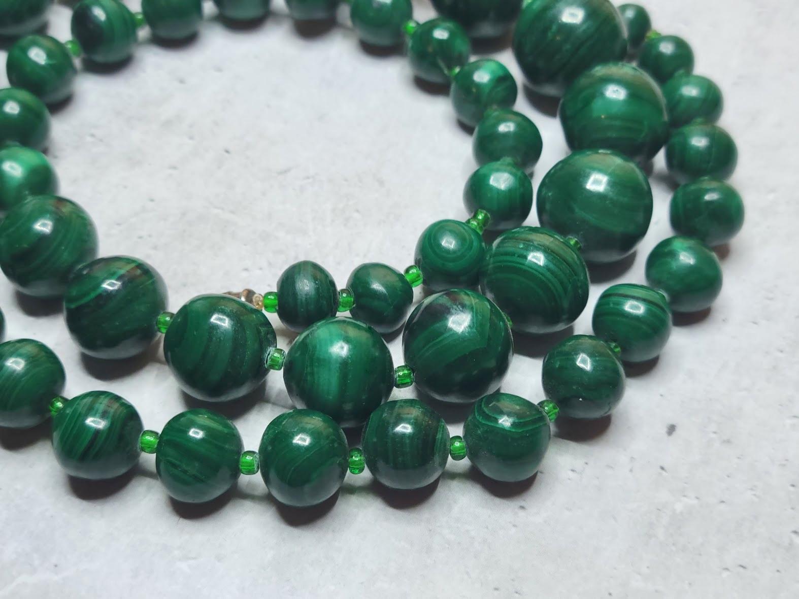 One strand graduated beaded necklace of vintage Russian Ural malachite separated by tiny vintage Czech glass beads with an old screw clasp. 
The length of the necklace is 26 inches (66 cm).
The size of malachite beads varies from 8 mm to 18 mm.
The