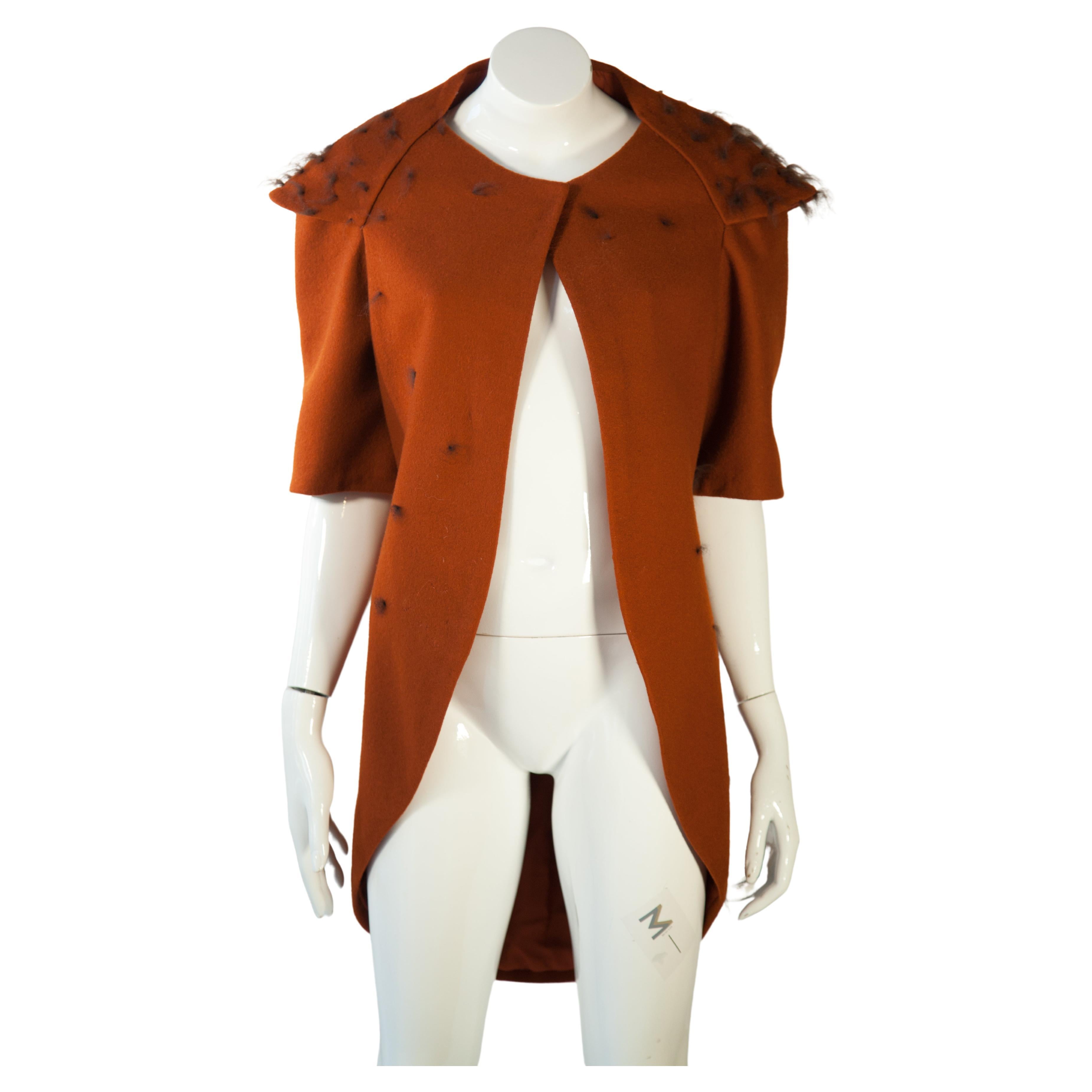 This Very Vintage Orange-Brown Color Dovetail cut jacket is a one-of-a-kind piece featuring rust-colored felt and detachable sleeves that provide versatility in style. Fur detail on the back and throughout increase visual interest and add a unique