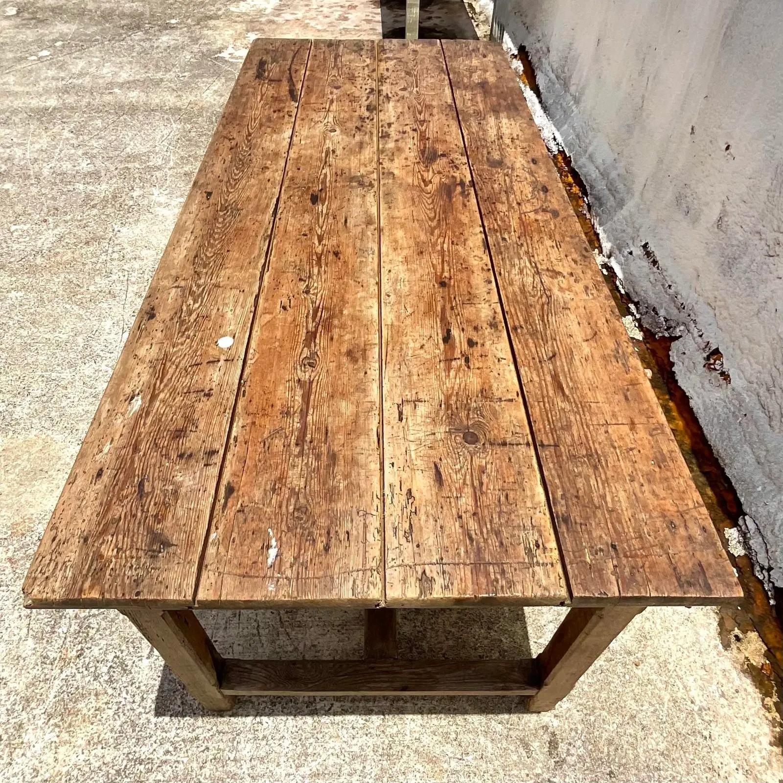 Vintage Boho dining table. A primitive piece with all the distressed charm of vintage farm table. Drawers underneath for additional storage. Acquired from a Palm Beach estate.