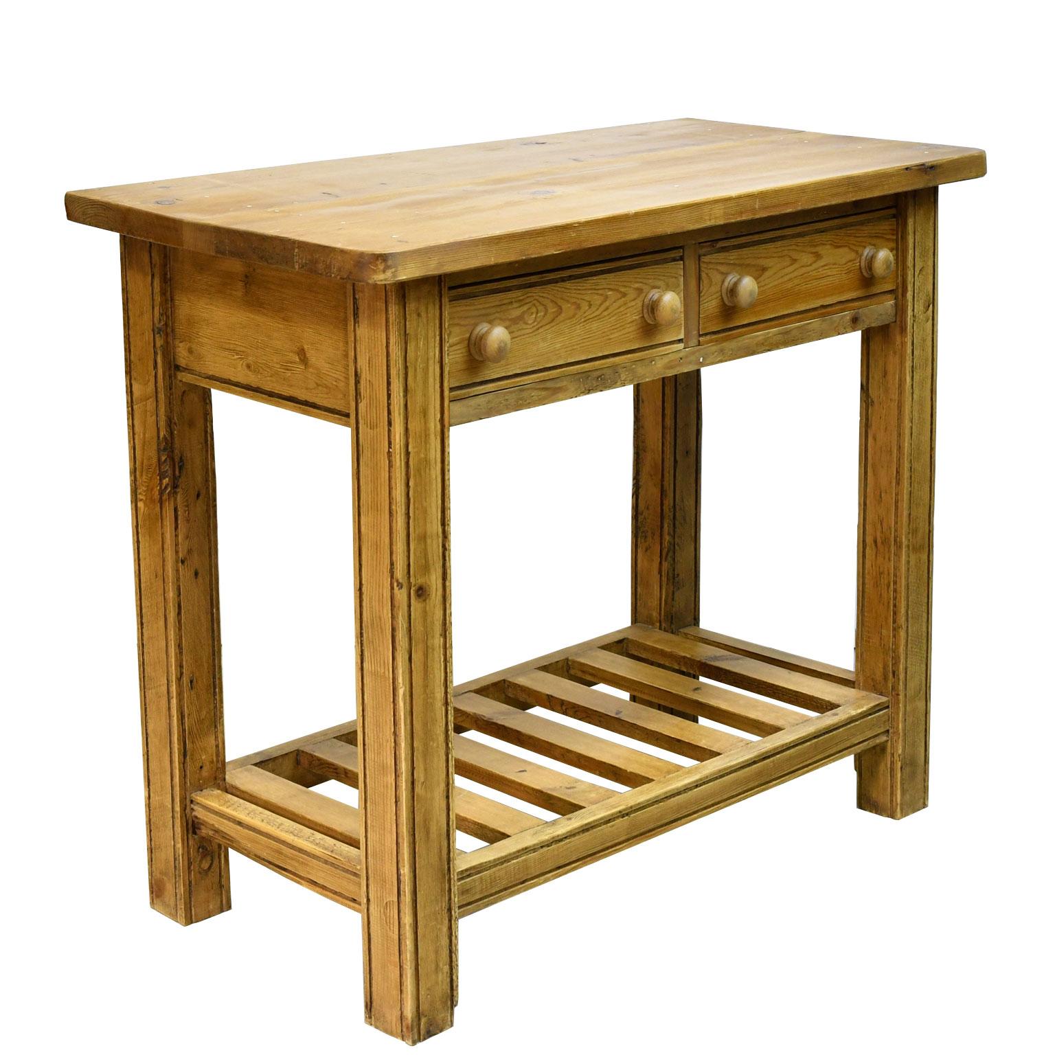 A vintage and rustic English pine table made from antique elements and repurposed wood with square legs, two drawers with turned knobs, and bottom shelf. Lots of charm and character!
Size: 37 3/8