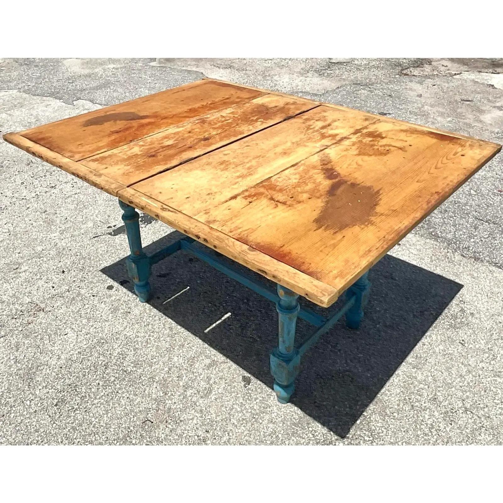 Fantastic vintage Rustic farm table. Beautiful turned legs painted a bright blue. The table top turns and flips open to create a larger surface. A fabulous all over patina from time. Lots of gnarly blemishes and stains that you look for in a farm