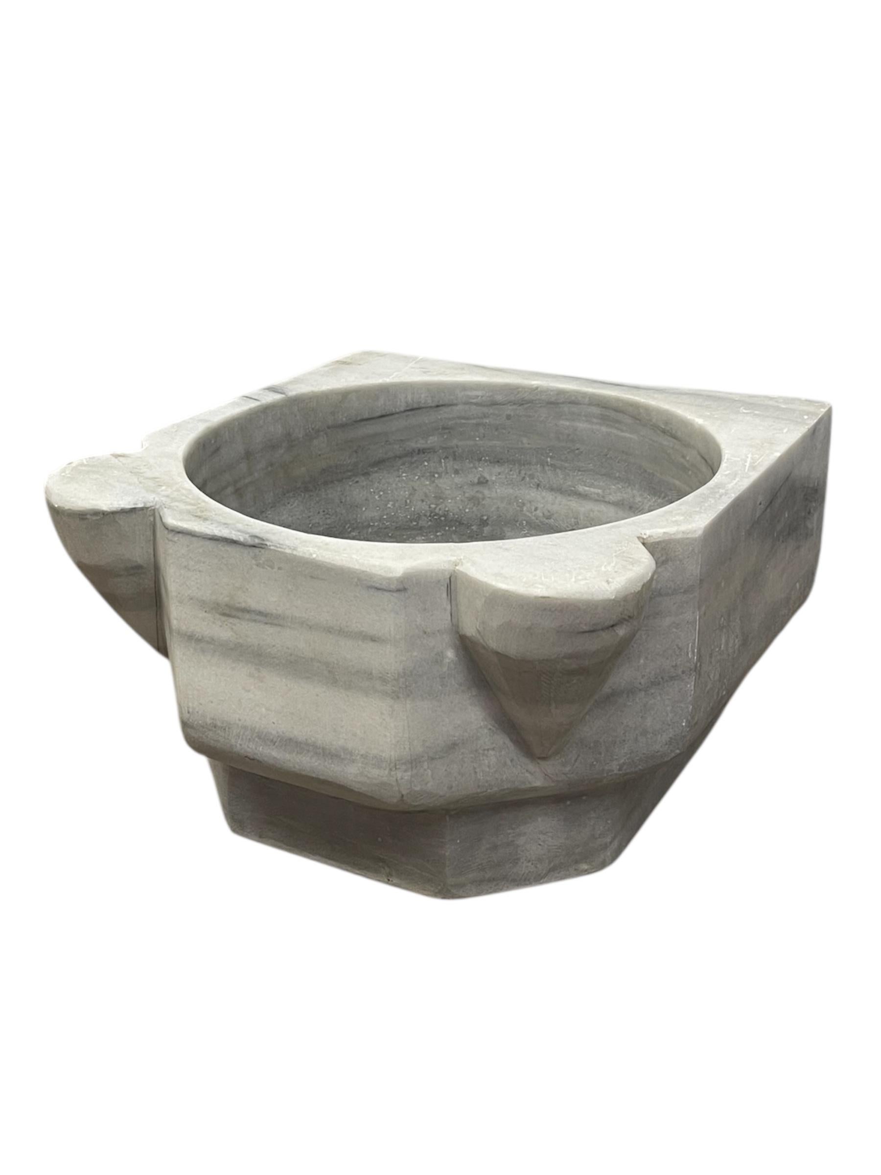  Questo lavabo in marmo vintage presenta un design rustico intagliato a mano con un esterno esagonale accentuato da sporgenze sottilmente arrotondate sui lati opposti e una profonda vasca interna circolare.
Realizzato in marmo massiccio, il pezzo