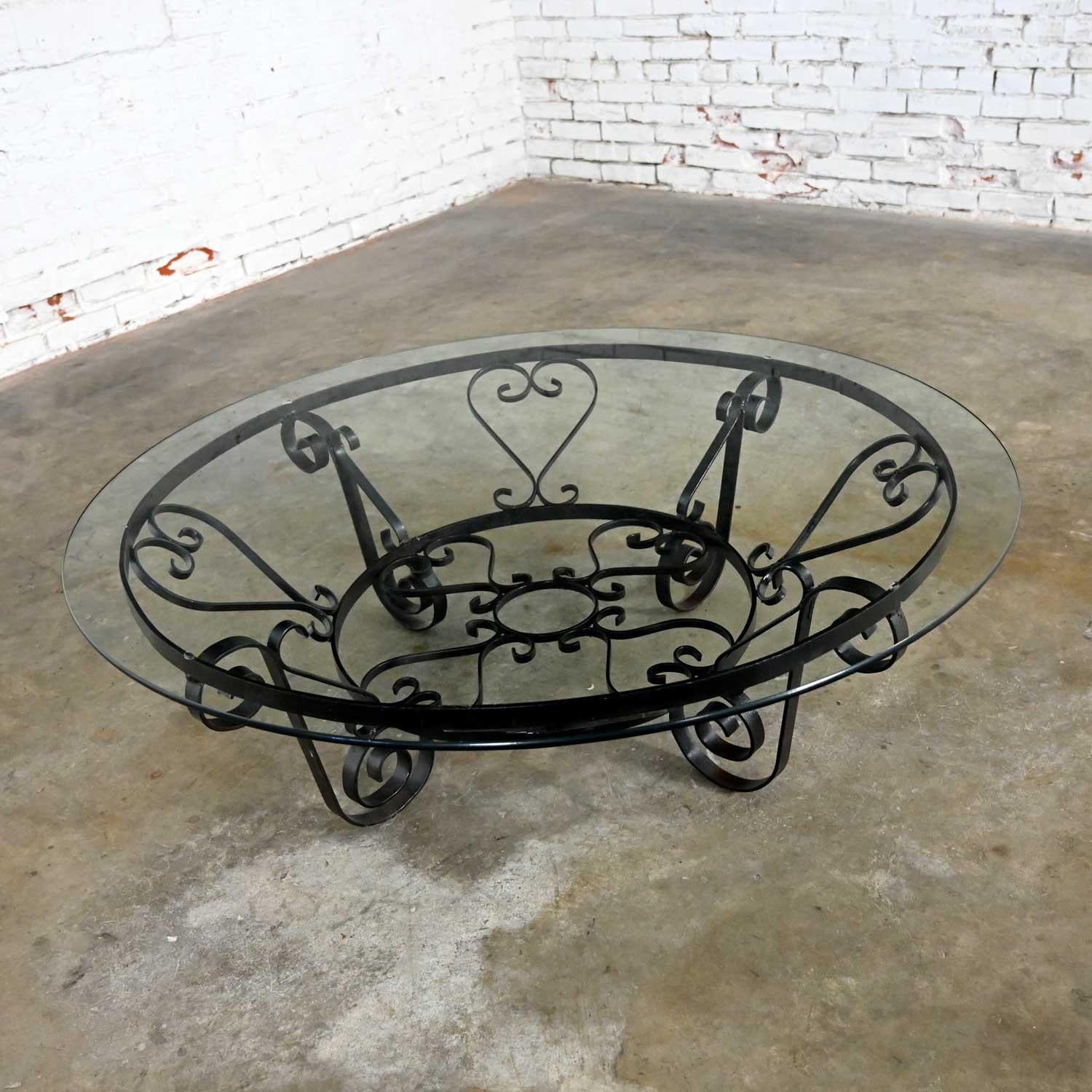 Awesome round rustic hand wrought iron coffee table with 3/8 in. thick 48-inch round glass top. Beautiful condition, keeping in mind that this is vintage and not new so will have signs of use and wear. The base has rust and distressed all-over