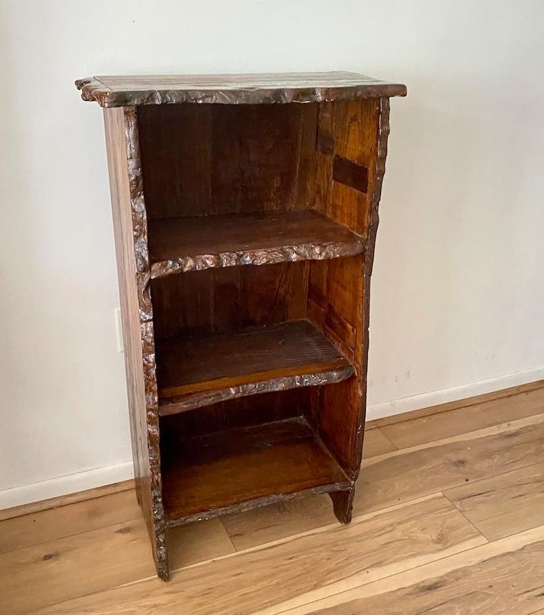 This bookshelf boasts a distinctive design featuring the natural beauty of live edge walnut wood. It offers ample storage space and sturdy construction, making it a practical and stylish choice for any home or office.

Dimensions:
the top is 23x13