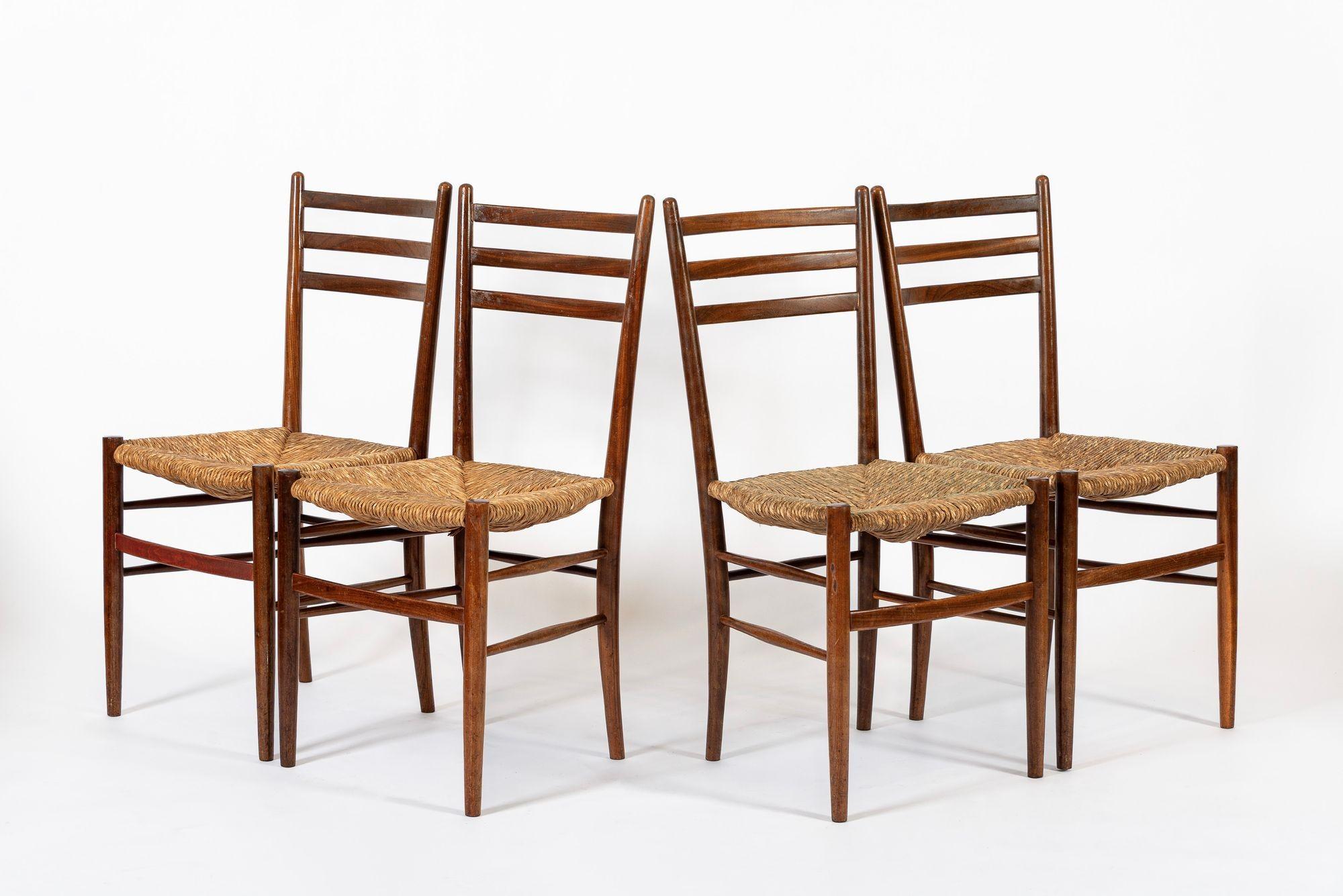 This set of four vintage rustic modern side chairs are circa 1960. The classic and elegant design features solid wood frames with three-rung ladderback backrests and natural woven rush wicker seats. These versatile and timeless vintage chairs pair