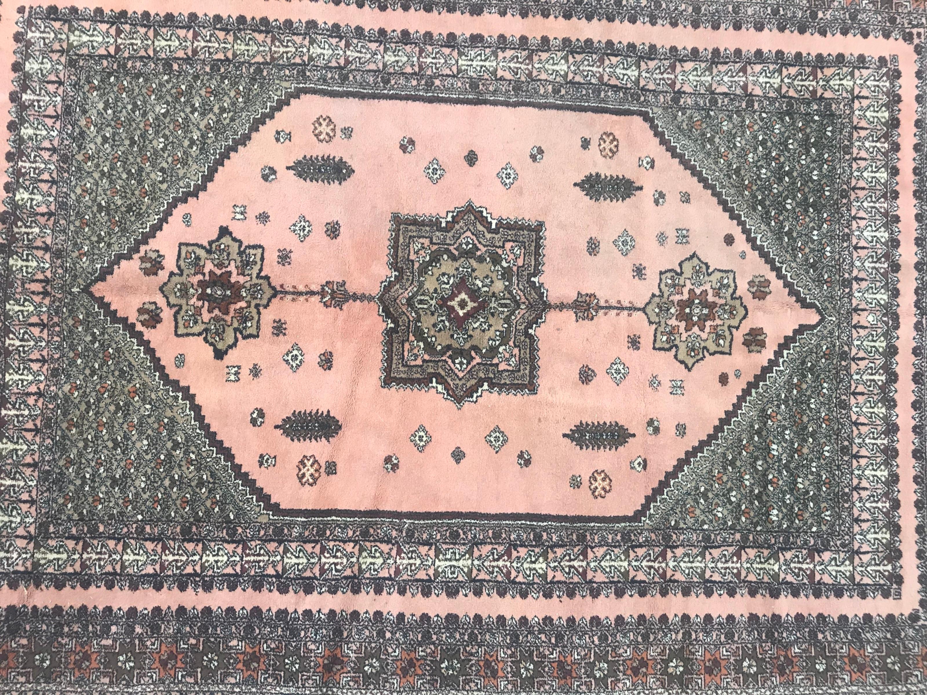 Preciosa alfombra marroquí de mediados de siglo con un diseño geométrico con medallón central y flores estilizadas y un campo rosa con verde, naranja, morado y negro, anudada totalmente a mano con terciopelo de lana sobre base de lana.