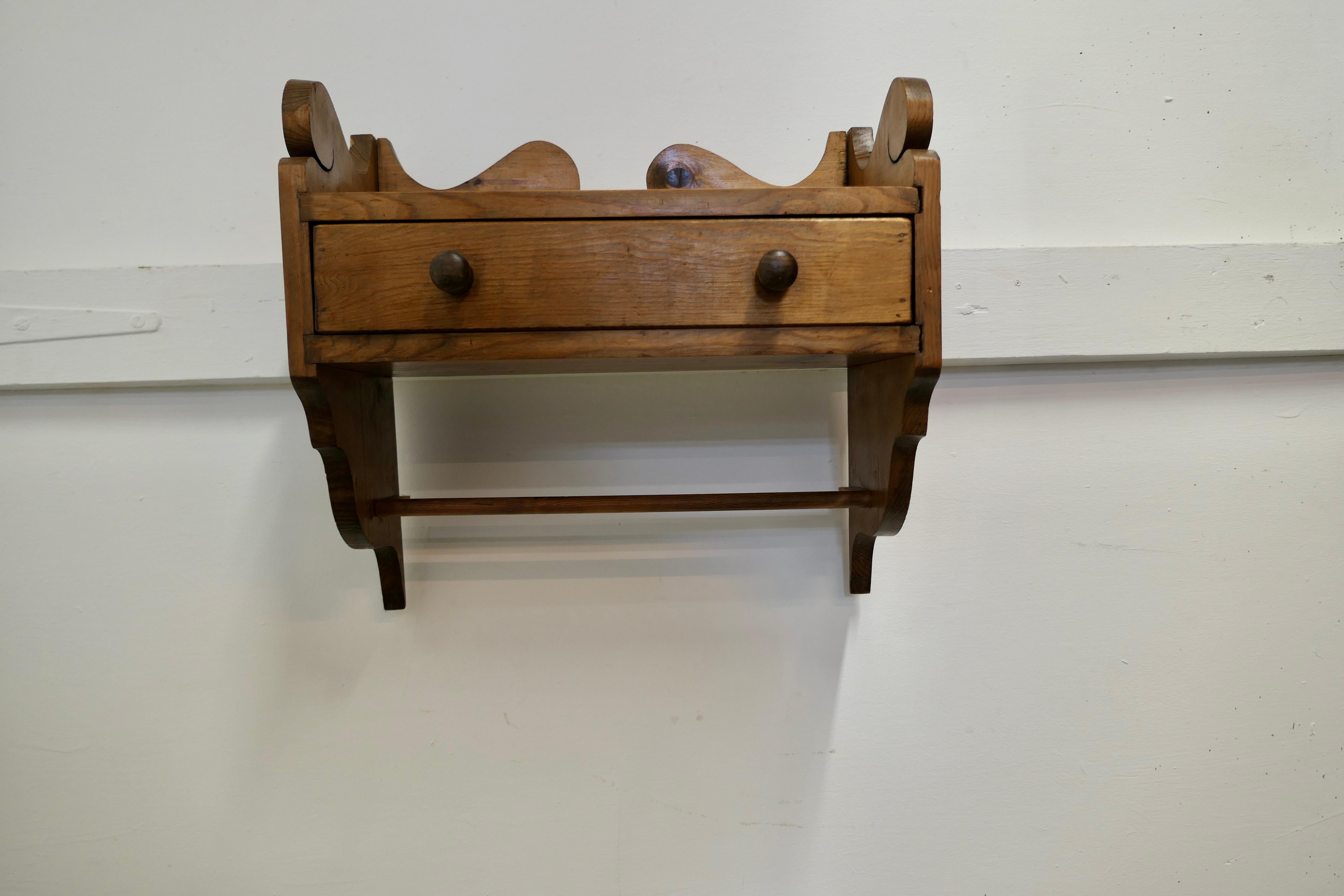 Vintage Rustic Pine Folk Art Wall Shelf with drawer.

This charming little wall hanging shelf has a small drawer with a towel rail beneath
The shelf is 15” high, 17” wide and 8” deep
TJK274.