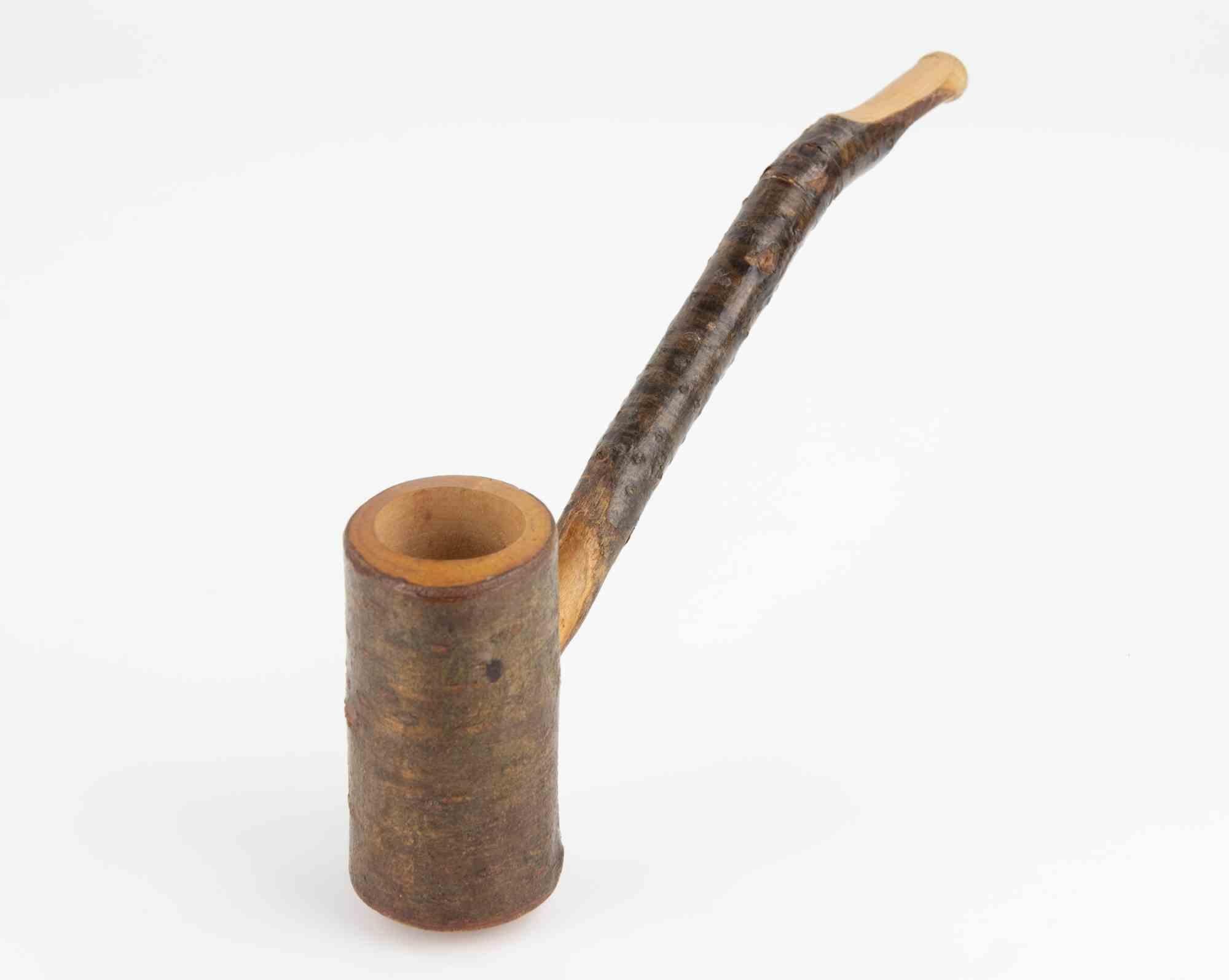 Pipa da fumo in legno rustica e artigianale, realizzata interamente a mano in legno naturale. La ciotola è formata da un pezzo di legno cilindrico, lasciato allo stato naturale con la corteccia ancora visibile, che gli conferisce un carattere grezzo