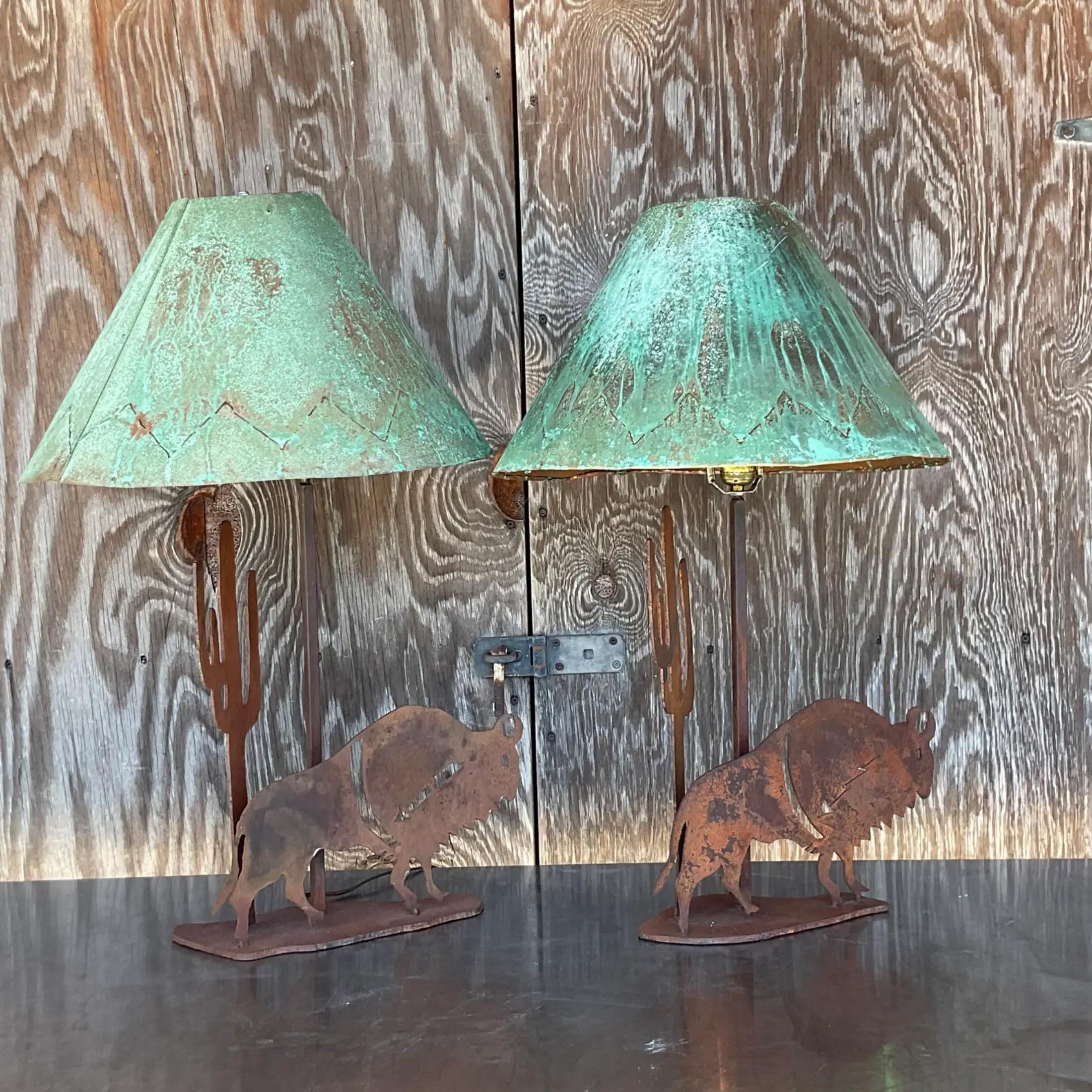 A fantastic pair of vintage Rustic table lamps. Fab punch cut metal buffalos with an all over rusted finish. Coordinating patinated metal shades. Acquired from a Palm Beach estate