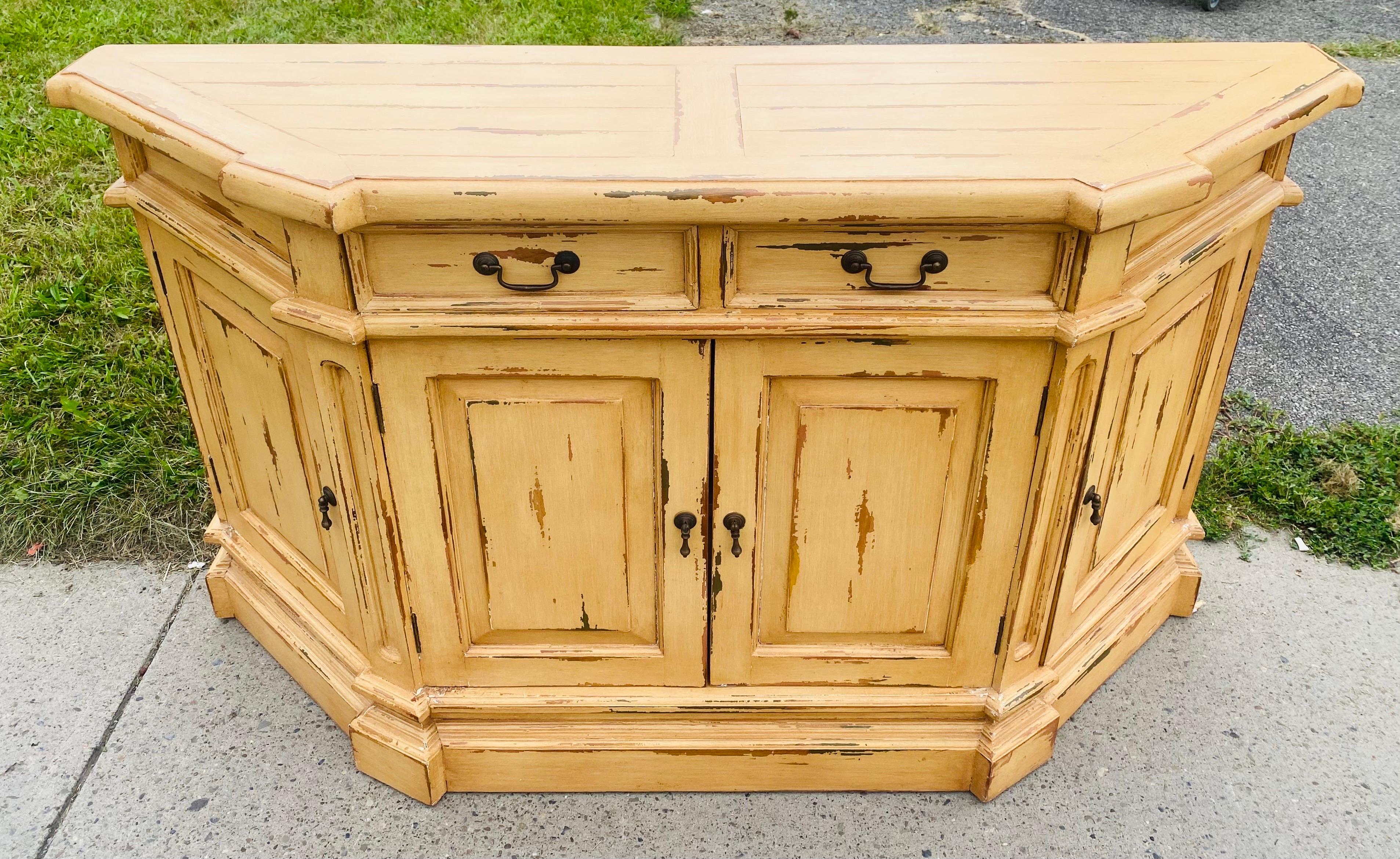 Si tratta di una credenza vintage rustica shabby chic a quattro ante. Questo mobile ha due ante principali nella parte anteriore.  sull'angolo laterale Ci sono due porte che si aprono con scaffali triangolari. La credenza è dotata di due cassetti