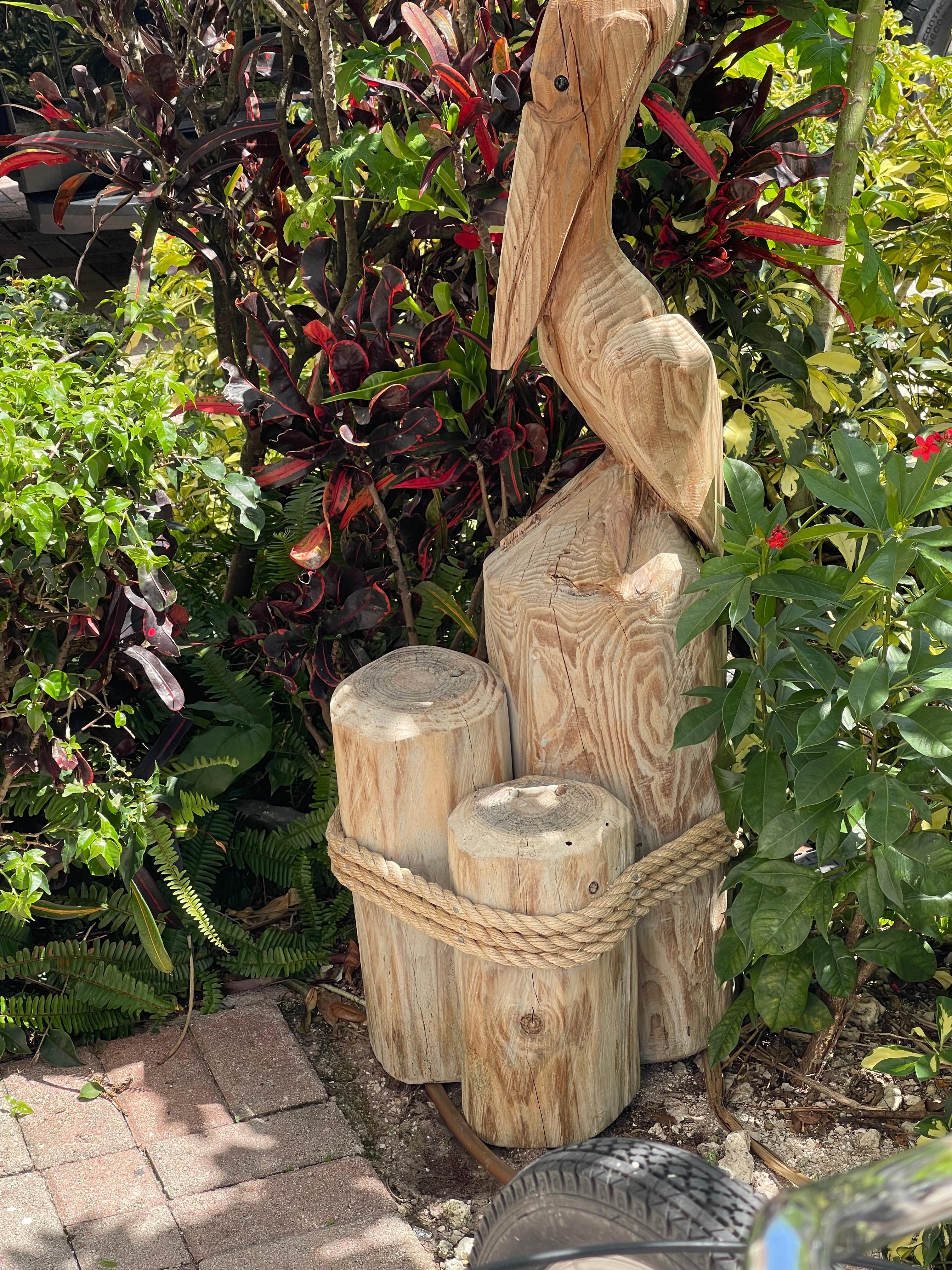 Vintage handgefertigte Holzküstenskulptur eines Pelikans auf Holzblöcken.