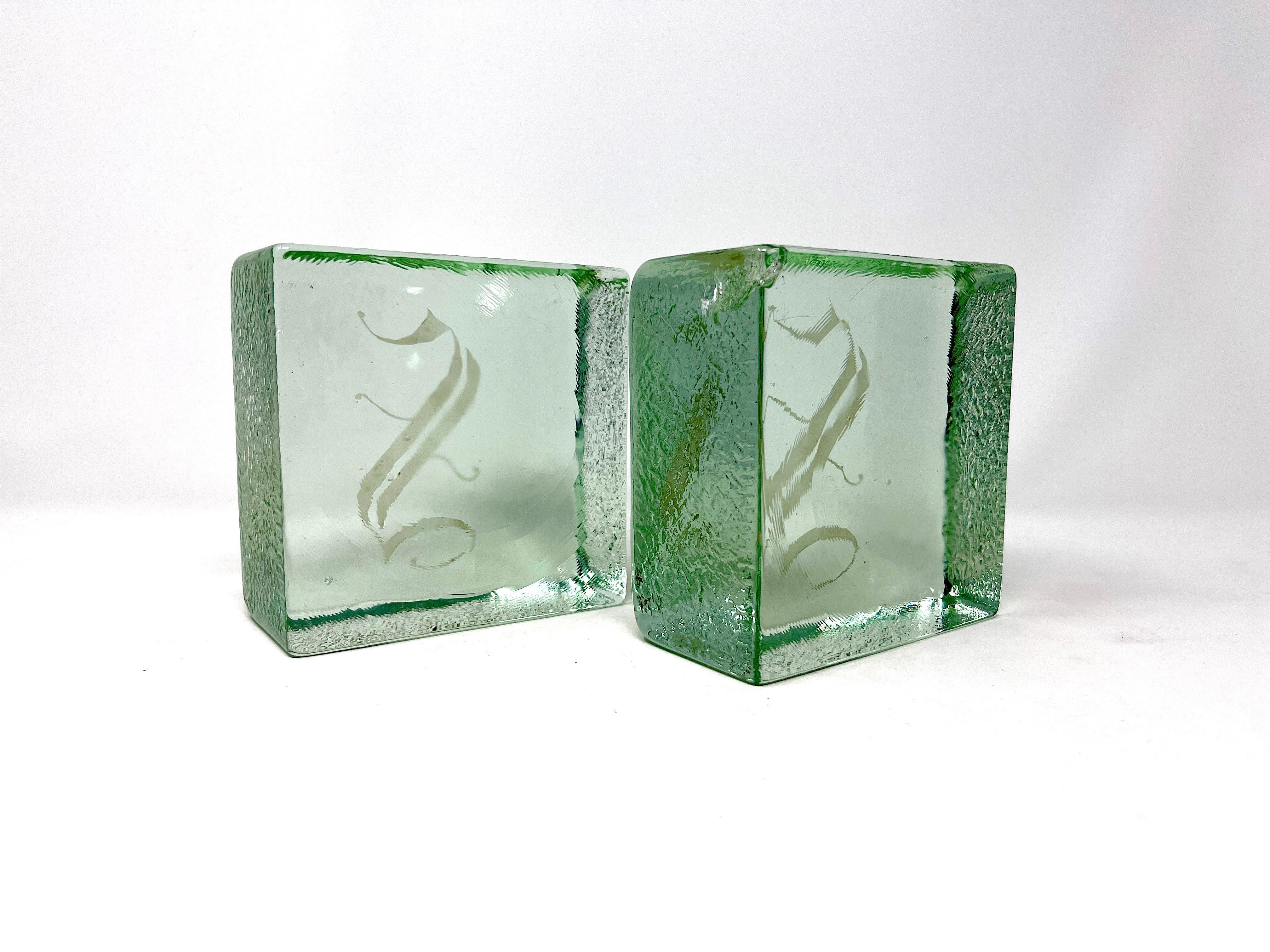 Bonito par de sujetalibros de mediados de siglo en forma de cubo de hielo de Blenko con el monograma de la S mayúscula. El anverso y el reverso están pulidos lisos y los cuatro lados están texturizados.

En buen estado vintage. Hay una rotura