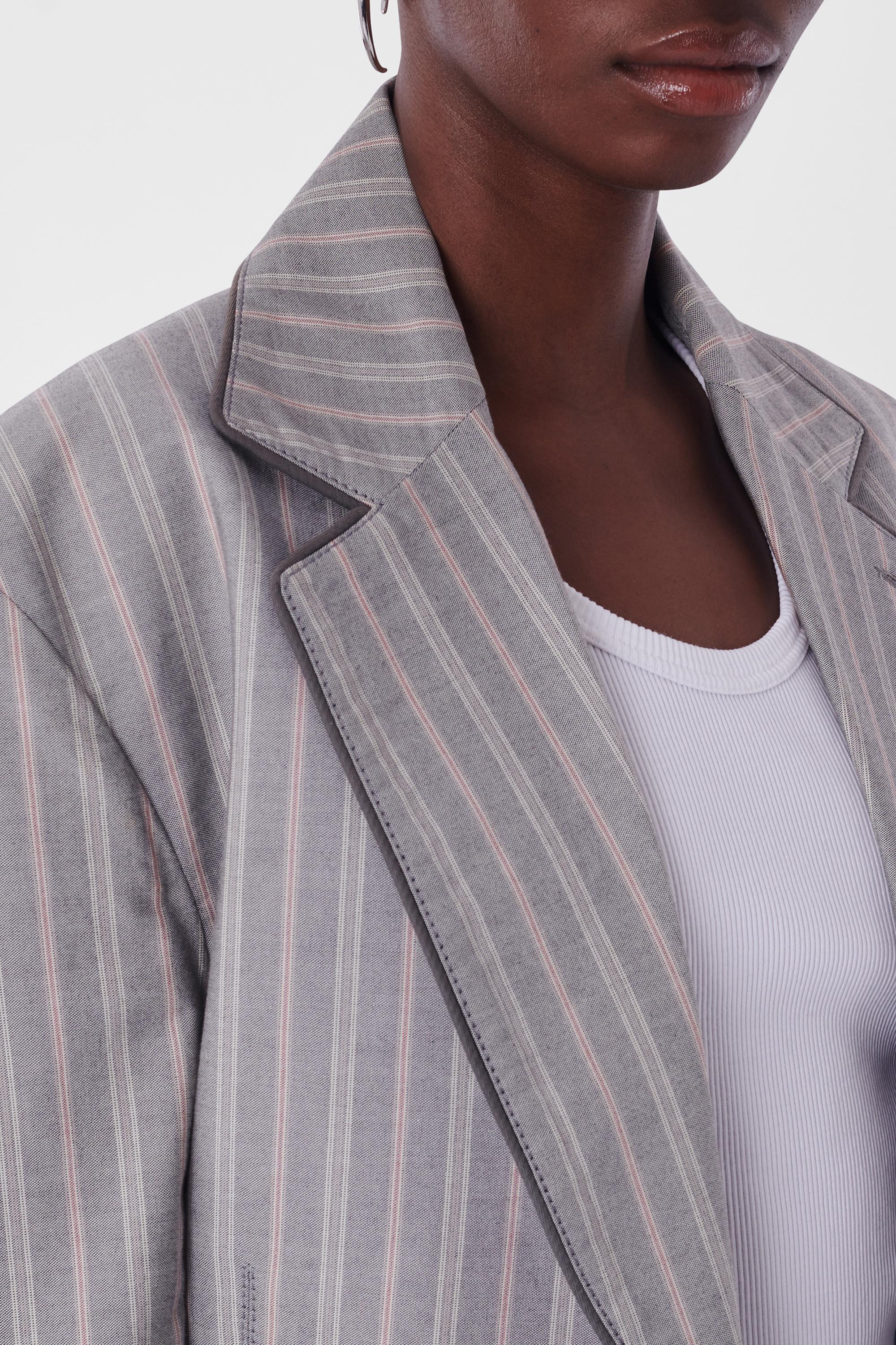Vivienne Westwood Vintage S/S 1991 Pinstripe grey Suit. Il est doté d'une seule poitrine, d'un passepoil gris le long du revers, de 4 poches sur le devant, d'une coupe ajustée et d'une fermeture à glissière le long de l'entrejambe du pantalon avec