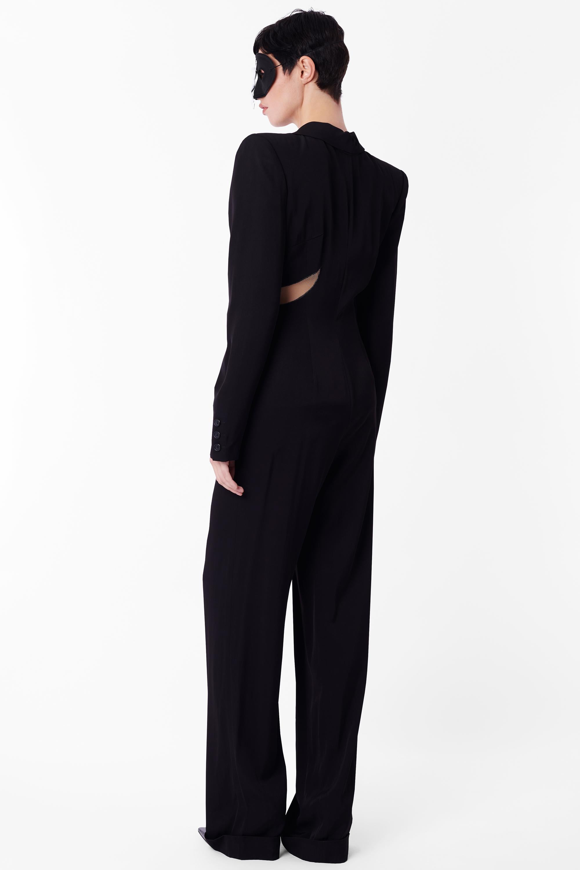 Vintage Alexander McQueen Spring Summer 1997 black jumpsuit, look 22 from the 'La Poupée' collection. Silhouette noire à manches longues avec partie supérieure structurée avec épaulettes, revers allant jusqu'au bas de l'abdomen, centre transparent
