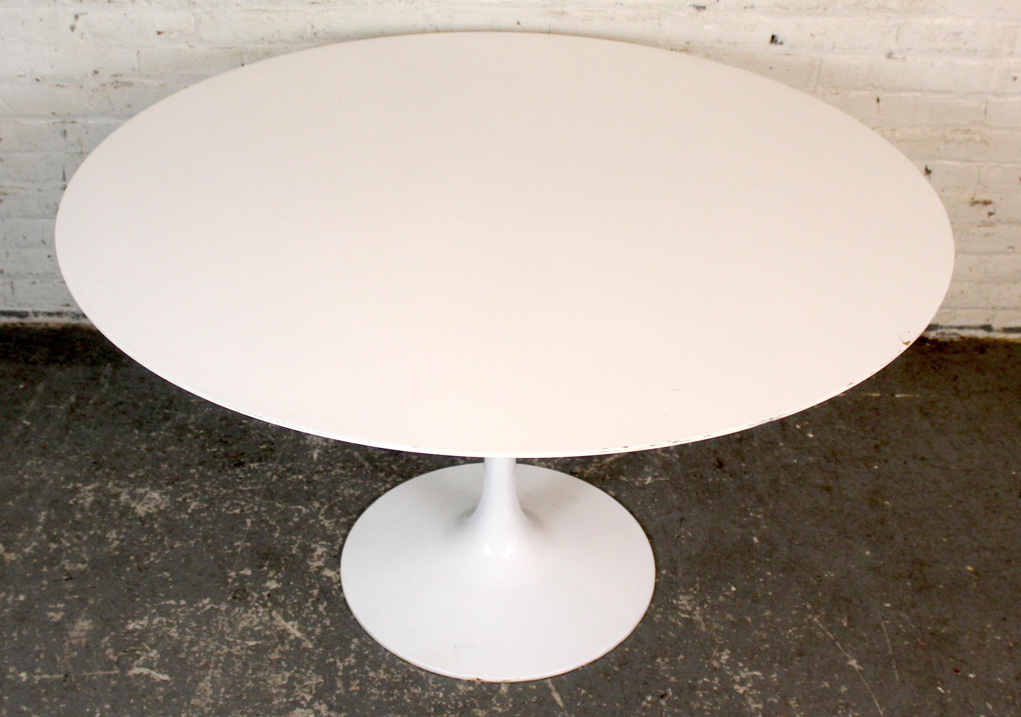 An iconic Mid-Century Modern white tulip dining table, inspired by the revolutionary designs of Eero Saarinen. Featuring a sleek, pedestal base that eliminates visual clutter and leg interference, the table offers a clean, sculptural silhouette. The