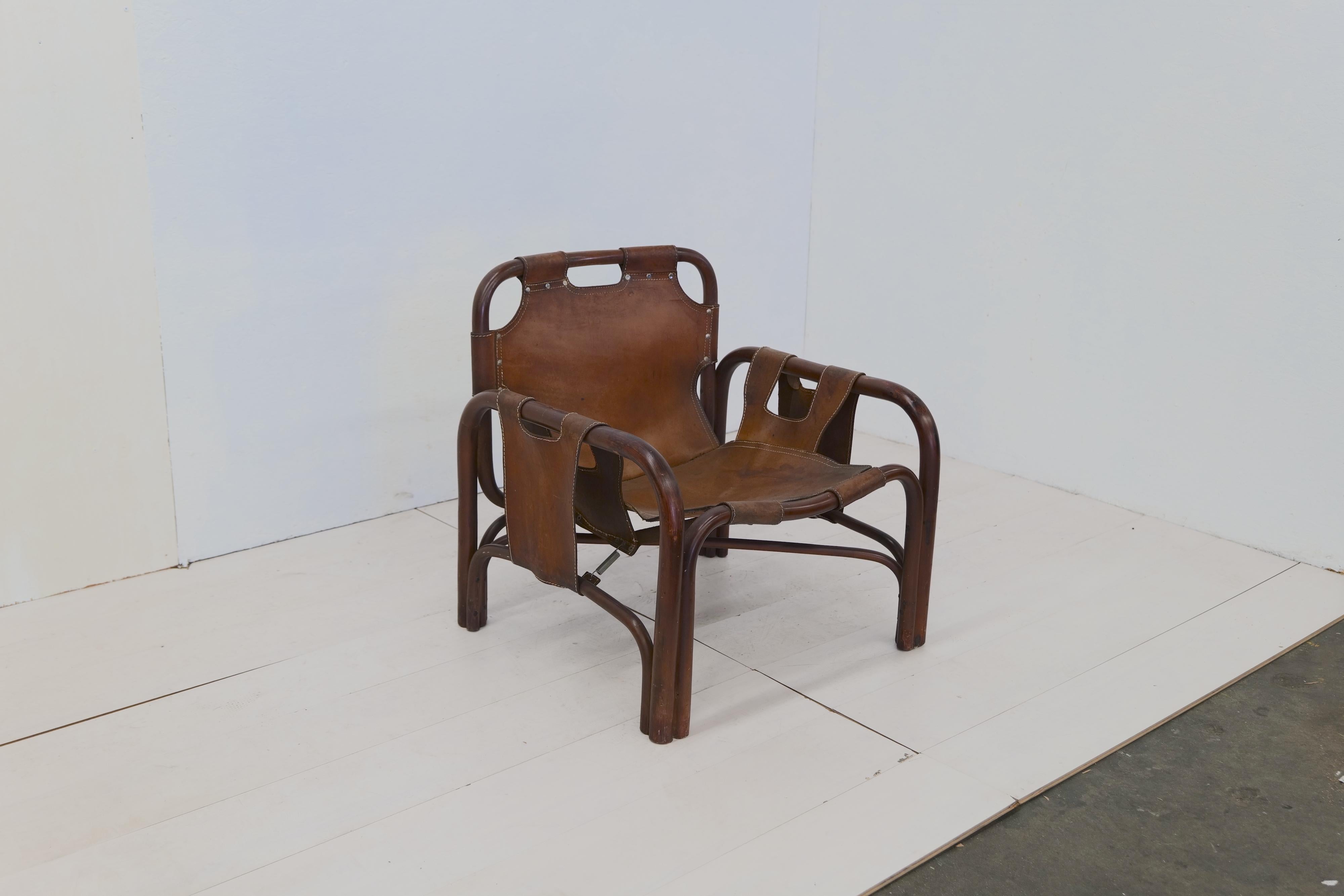 Der Vintage-Safarisessel, den Tito Agnoli in den 1960er Jahren für Bonacina entworfen hat, strahlt Abenteuerlust und zeitlose Eleganz aus. Dieser Sessel aus einer Kombination von Rattan und Leder bietet eine einzigartige und fesselnde Ästhetik. Das