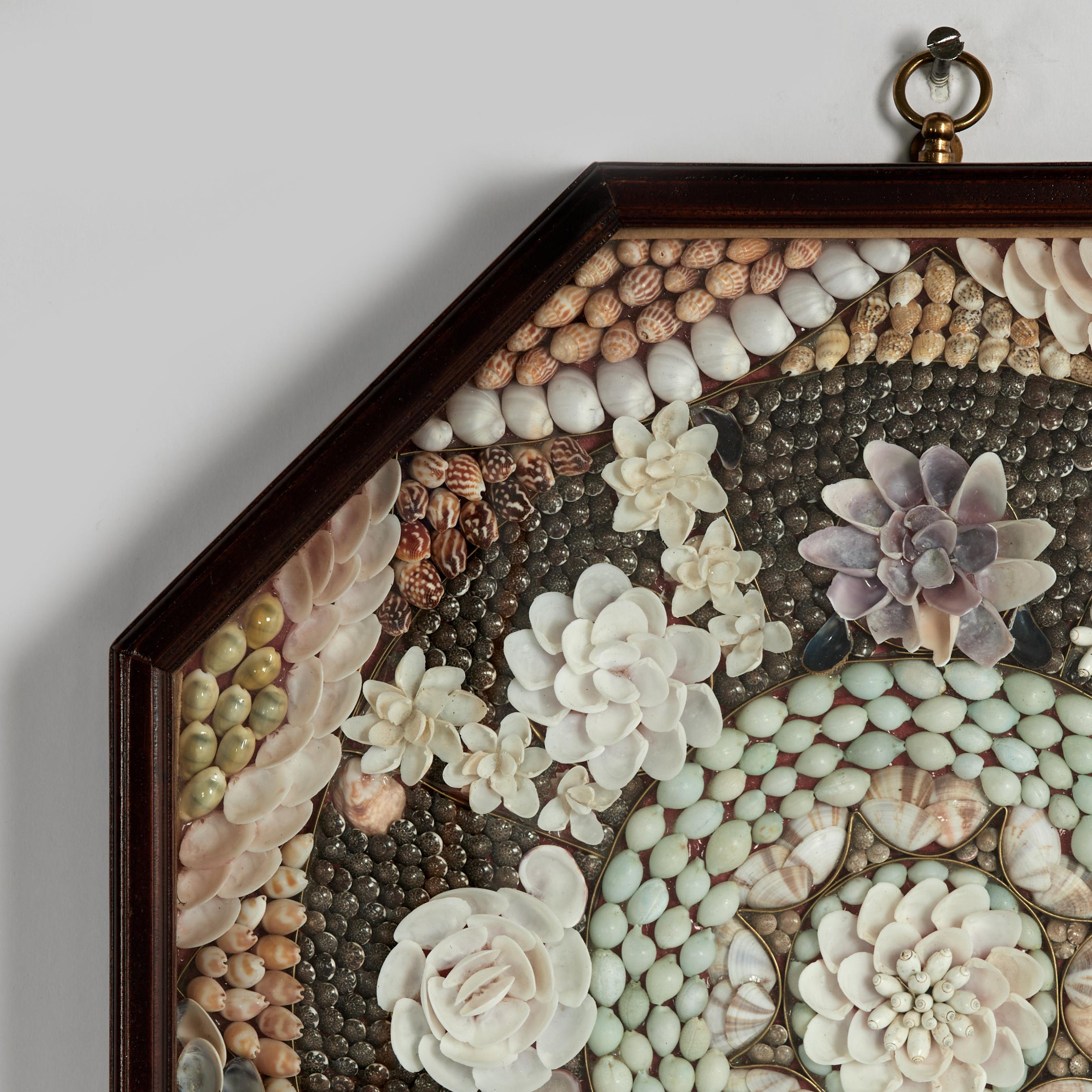 San Valentino dei marinai vintage realizzato a mano con conchiglie esotiche organiche in una deliziosa composizione di disegni floreali. Presentato sotto vetro in una scatola ottagonale in mogano.