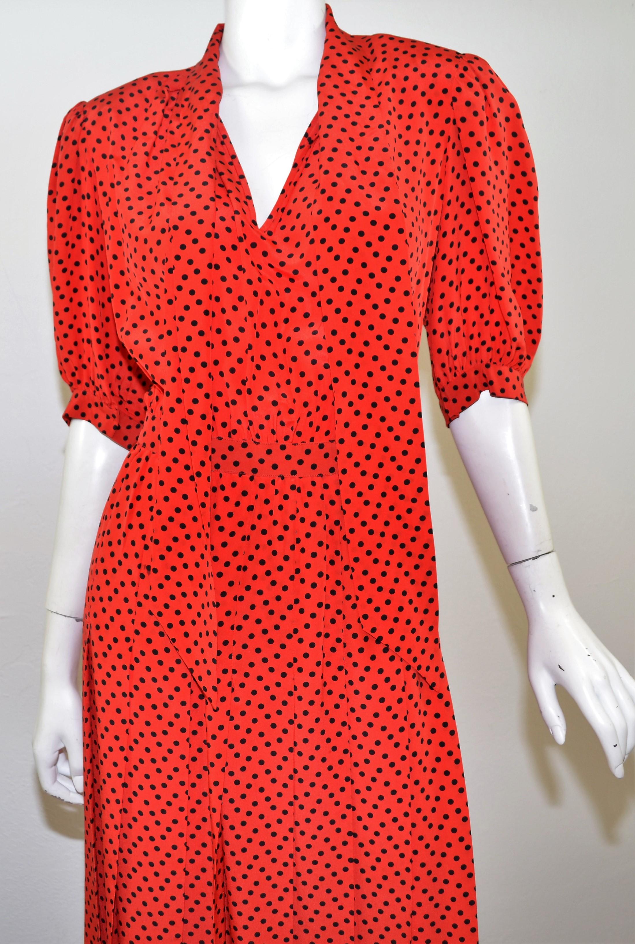 Vintage Saint Laurent dress is featured in red with a black polka-dot print pattern throughout and has a side zipper fastening, neck tie, and a pleated skirt. Made in France, size 42. 

Bust 38''
Waist 30''
Hips 38''
Length 44''
Sleeves