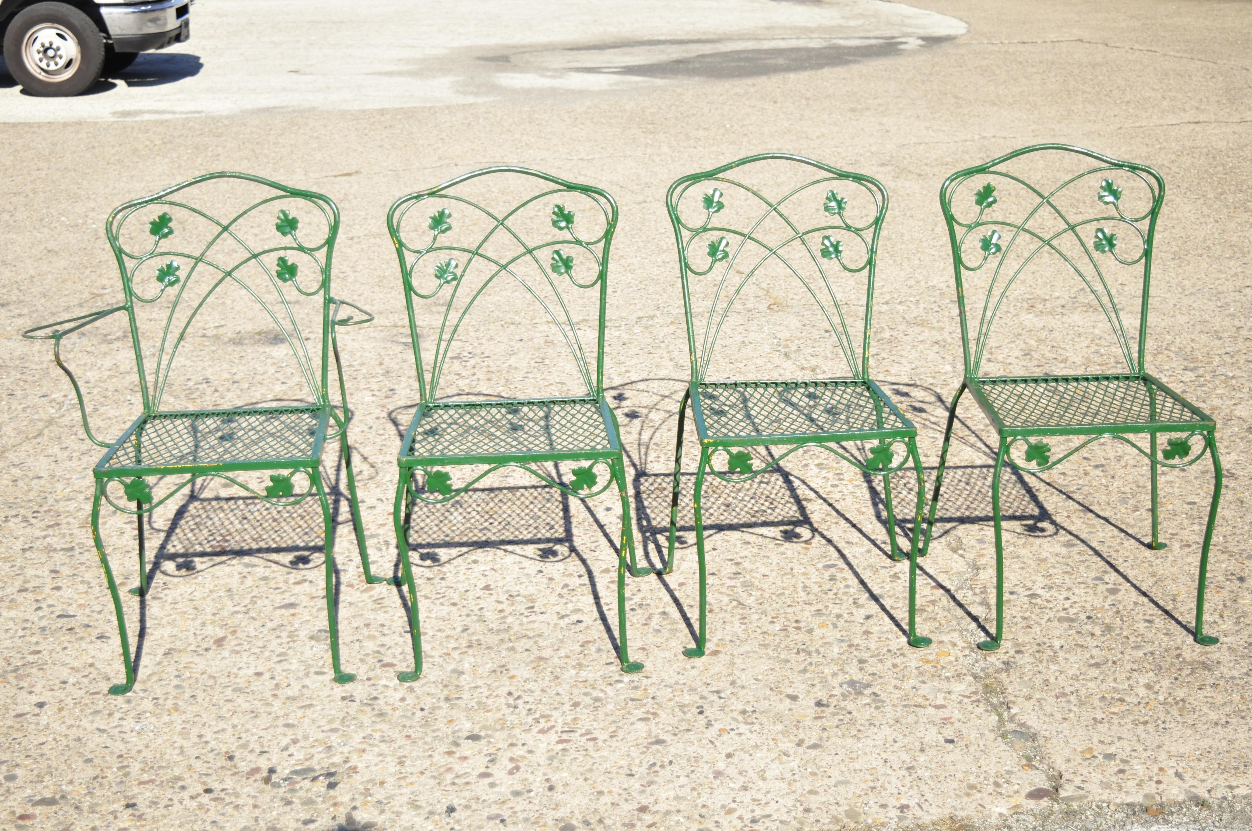 Vintage Salterini green wrought iron leaf scrollwork patio dining set, 5-piece set. Set includes (1) armchair, (3) side chairs, (1) rectangular table, leafy scrollwork design, mesh seat, wrought iron construction, great style and form, circa