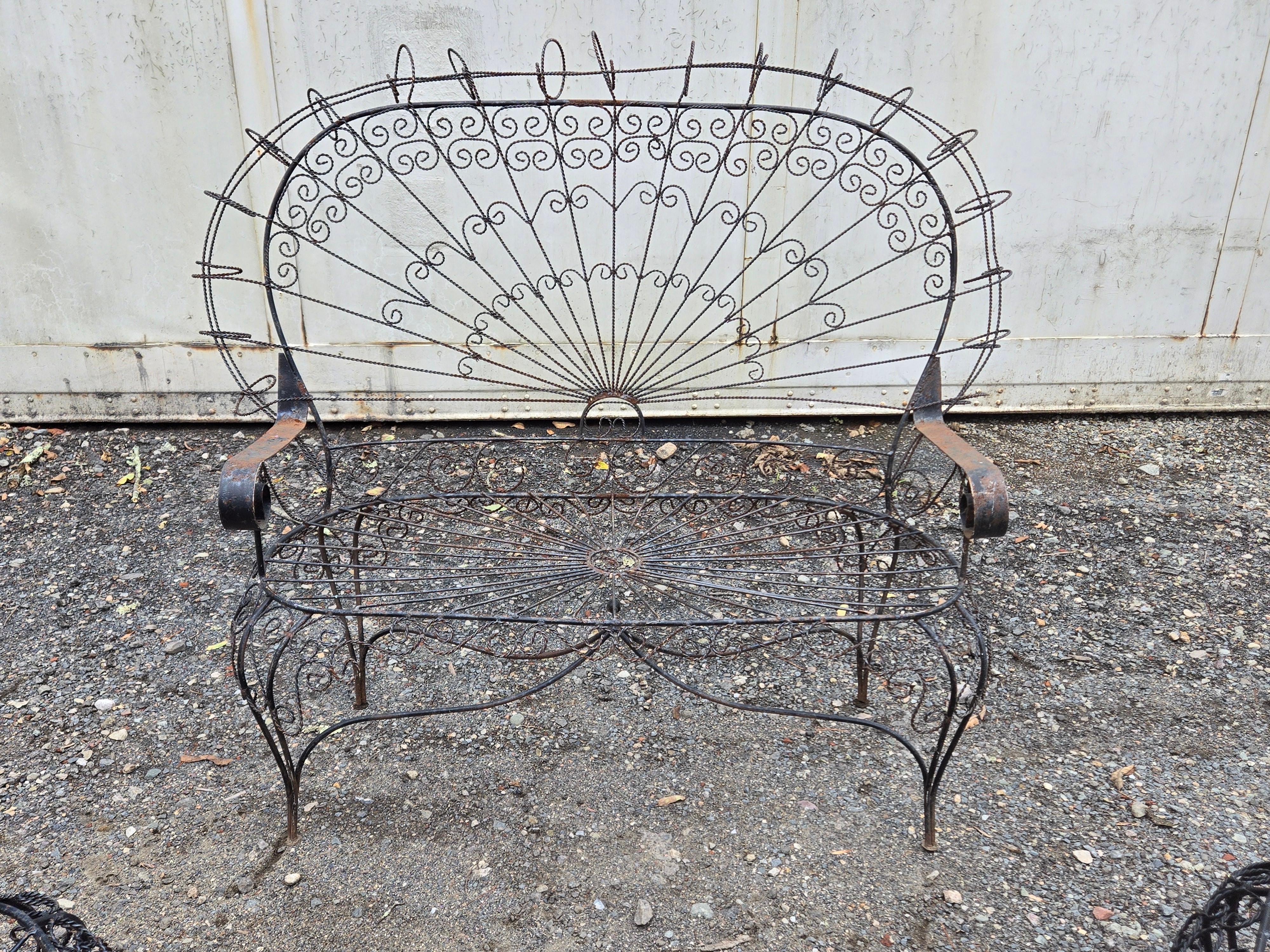 This vintage wrought iron patio furniture set from Salterini is perfect for outdoor relaxation with up to six people. The five-piece set includes a loveseat and four chairs, all made from durable wrought iron, iron, and metal materials. The black