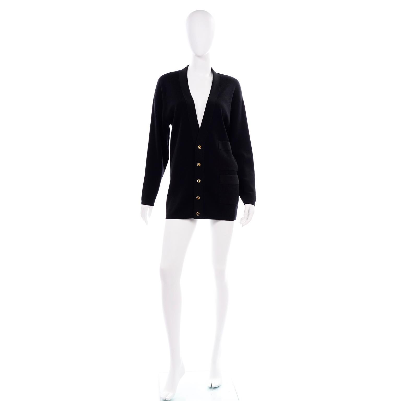 This is a timeless vintage Salvatore Ferragamo black wool cardigan with two tone metal buttons.  The collar and pockets have a tonal ribbon edges and one side of the cardigan has 2 stacked pockets. 
Made in Italy in the 1990's. . Labeled size XS.