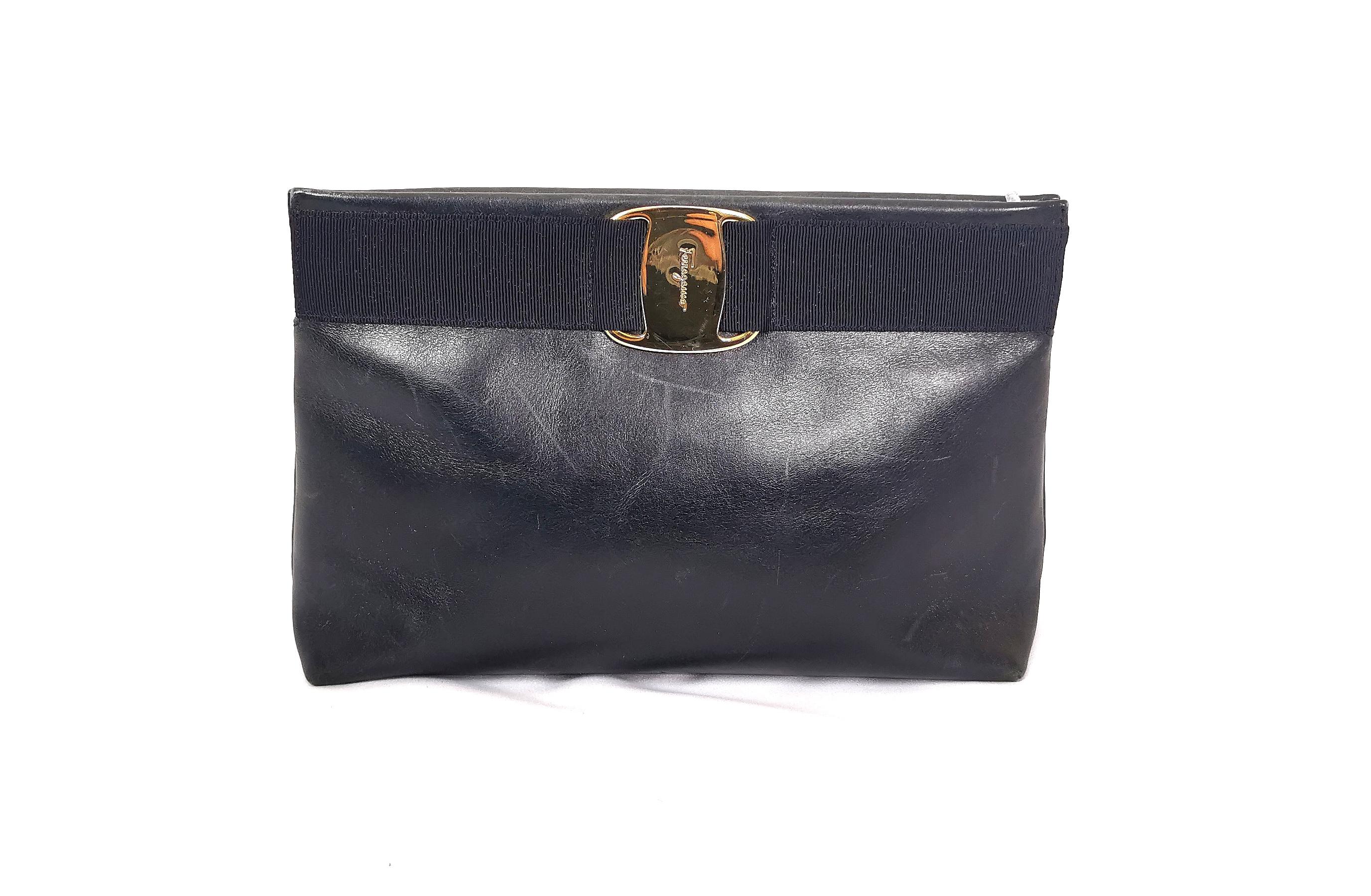 A stylish Vintage Salvatore Ferragamo shoulder x clutch bag.

This is a very versatile handbag and can be used as a clutch, crossbody or shoulder bag.

Made from Dark navy blue leather it has gold tone hardware with a wide elastic strap across the