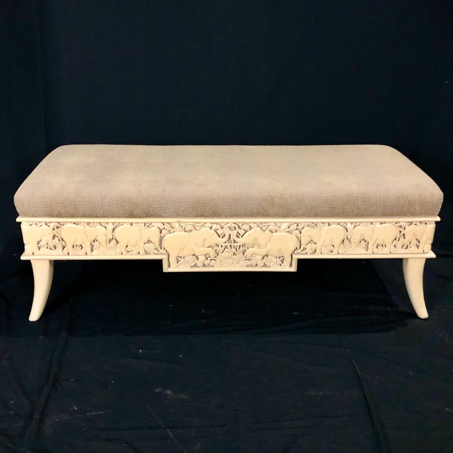 Beautifully carved wood bench by Sam Moore Furniture Company depicting elephants and foliage with a patterned top cushion that is reminiscent of an animal print. The cushion is plush and in very good condition (no stains or rips). Neutral colors