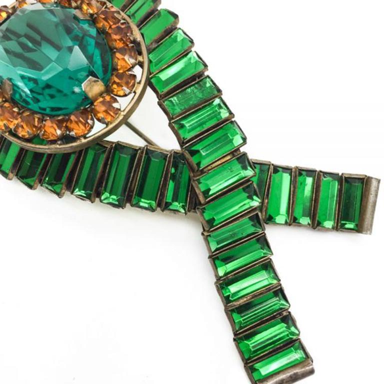 A very rare, large and stylish early signed Vintage Sandor brooch set in sterling silver and washed in a gold finish. The large central oval crystal is a delightful shade of aqua tinged green surrounded by round amber rhinestones. This central oval