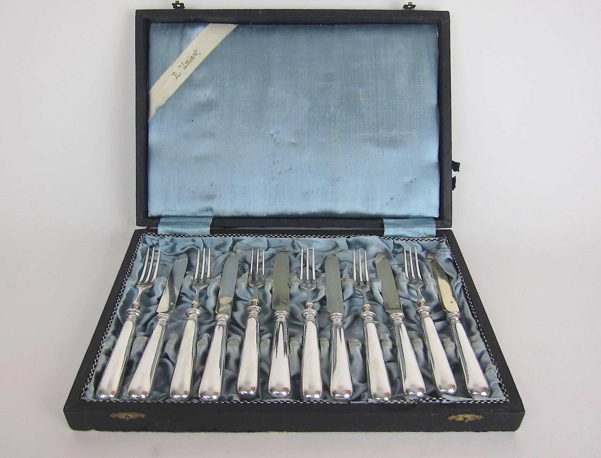 A vintage European silver-plated service for dessert, entremet, or fruit, comprised of six knives and forks by Sandrik, formerly of Austria-Hungary and Czechoslovakia. Designed in a simple and traditional style, the set dates to the 1930s and