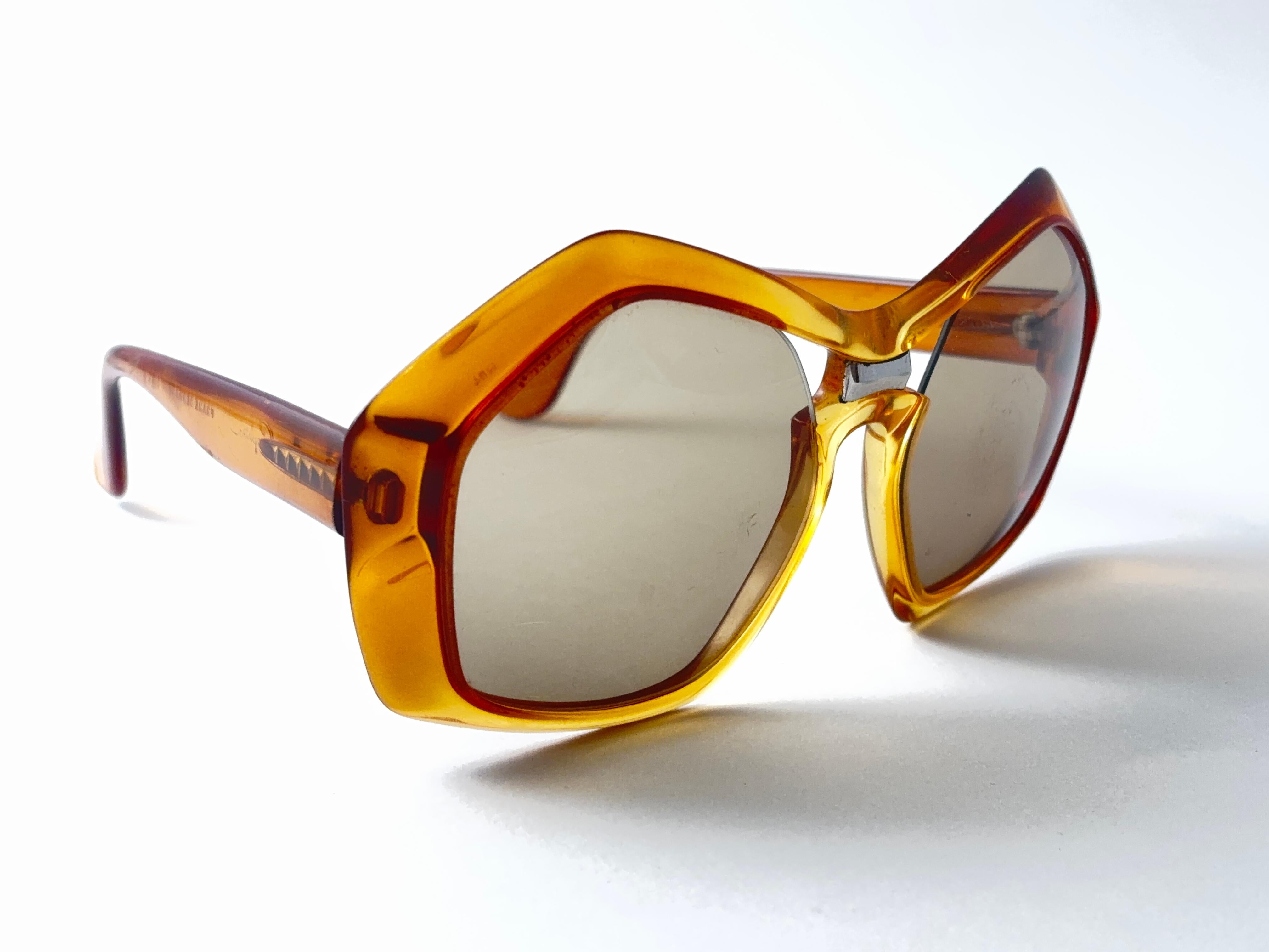 

New Vintage Saphira Translucent Amber & Honey Con Accenti Silver  Montatura di occhiali da sole con un paio di lenti originali marroni medie senza macchia.   

Questo articolo può presentare alcuni piccoli segni di usura dovuti alla conservazione