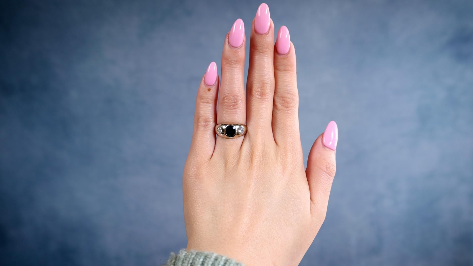 One Vintage Sapphire and Diamond 14k White Gold Three Stone Ring. Featuring one oval mixed cut dark blue sapphire weighing approximately 1.00 carat. Accented by two round brilliant cut diamonds with a total weight of approximately 0.45 carat, graded