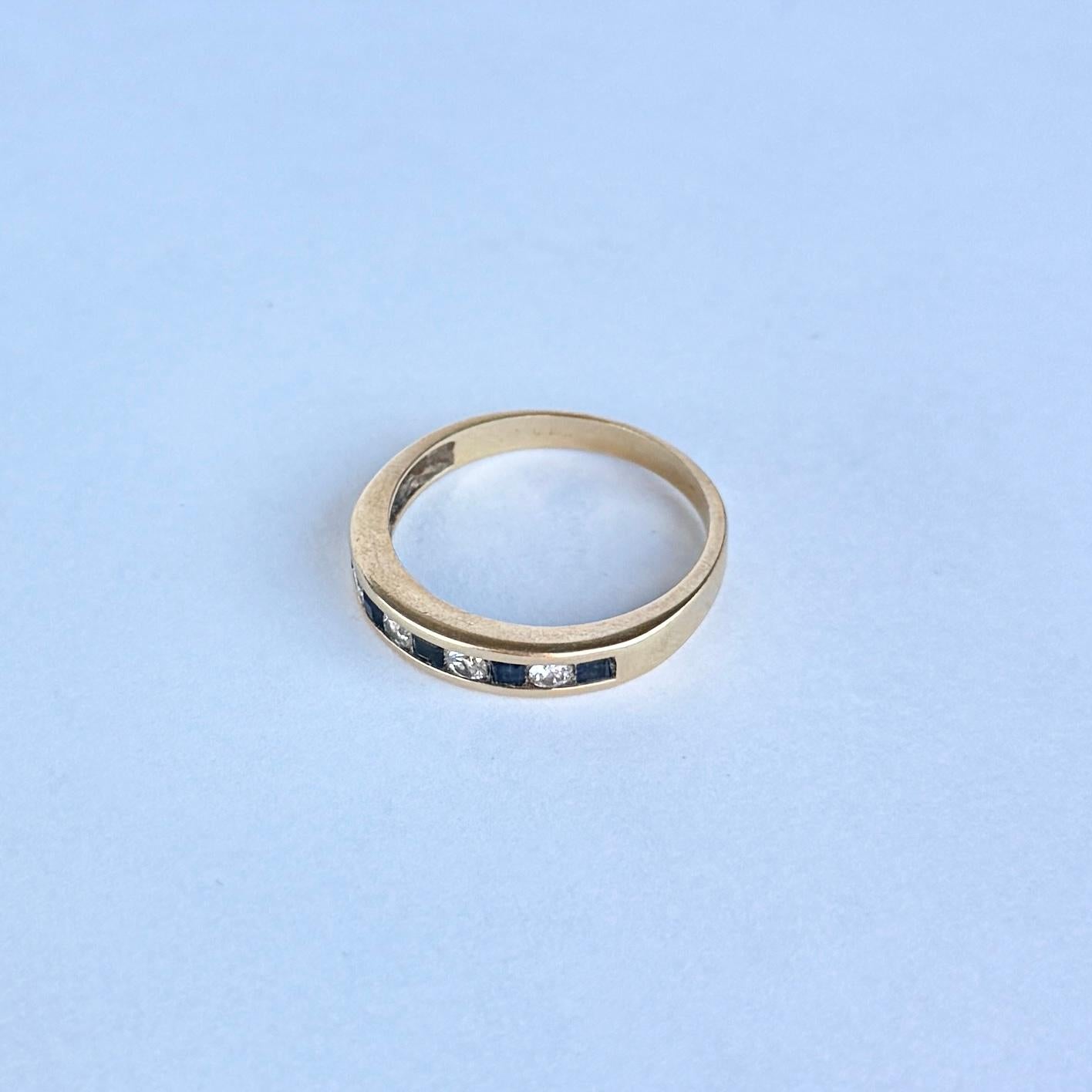 This gorgeous ring holds five deep blue sapphires. The central sapphire each measuring 5pts. The diamonds between these blue stones measure 5pts each also . Modelled in 18carat gold.

Ring Size: P 1/2 or 8 
Face Width: 4mm
Height Off Finger: