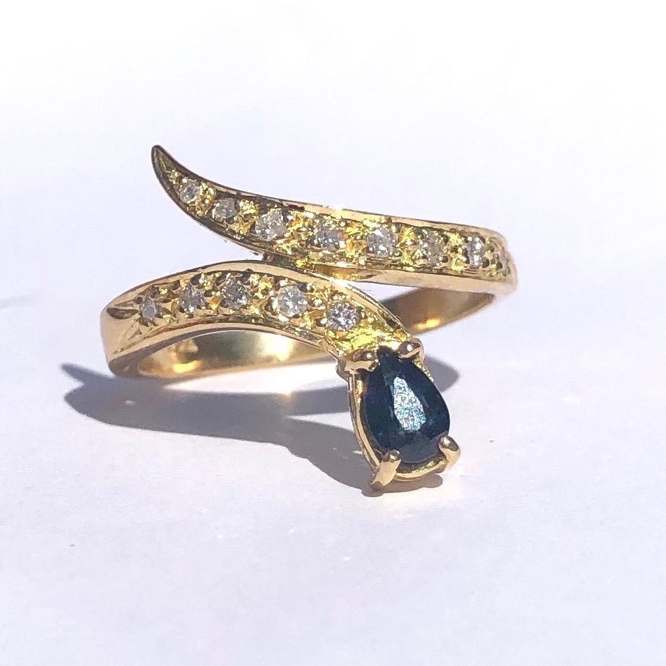 This stylish 18ct gold snake ring has so much shimmer and sparkle. The head holds an inky blue pear drop sapphire measuring approx 30pts and the body is adorned with 2pt diamonds. 

Ring Size: M 1/2 or 6 1/2 
Widest Point: 17mm 

Weight: 4g