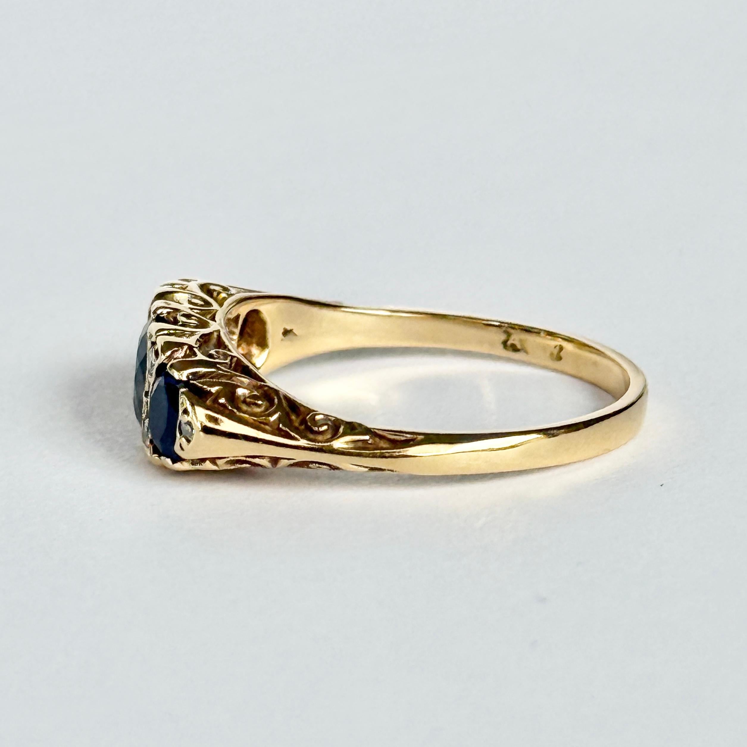 Lo zaffiro centrale misura 60pt e quelli laterali 25pt ciascuno. Tra le pietre blu si trovano coppie di  diamanti di 4pt per coppia. L'anello è realizzato in oro 18ct.  Punzonato Londra 1975.

Misura dell'anello: O 1/2 o 7 1/2 
Larghezza della