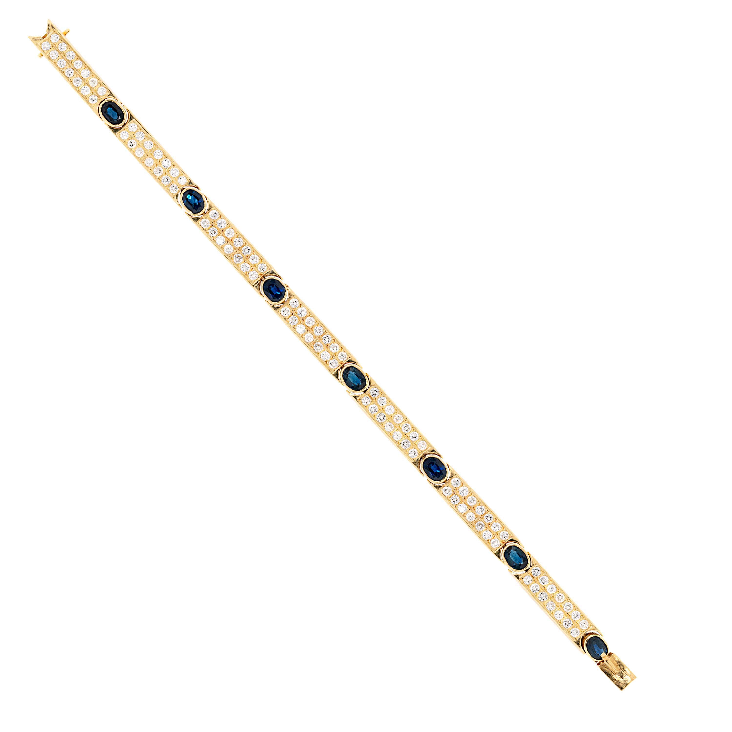 Vintage bracelet created with seven diamond set gold bars each connected by seven oval shaped blue sapphires weighing an approximate total weight of 5.00ct+ all mounted in open back rubover settings. The bracelet features a total of 98 fine quality