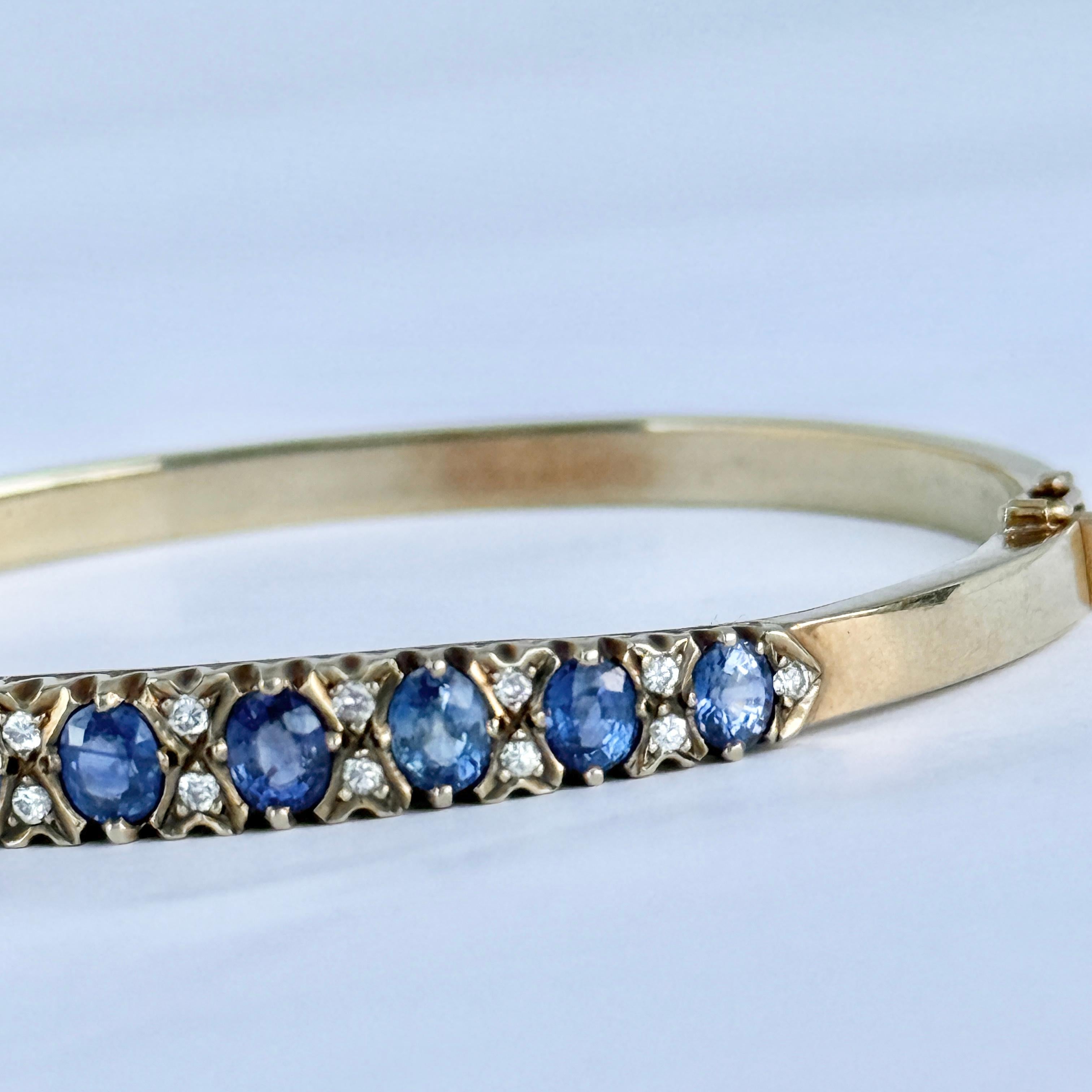 The detailed bangle holds Sapphires and diamonds. The detail on this bangle is stunning and so intricate. Sapphire total 2.2ct and Diamond Total 36pts.  

Inner Diameter Hinge to Clasp: 6cm
Inner Circumference: 17cm
Bangle Width: 6mm
 
Weight: