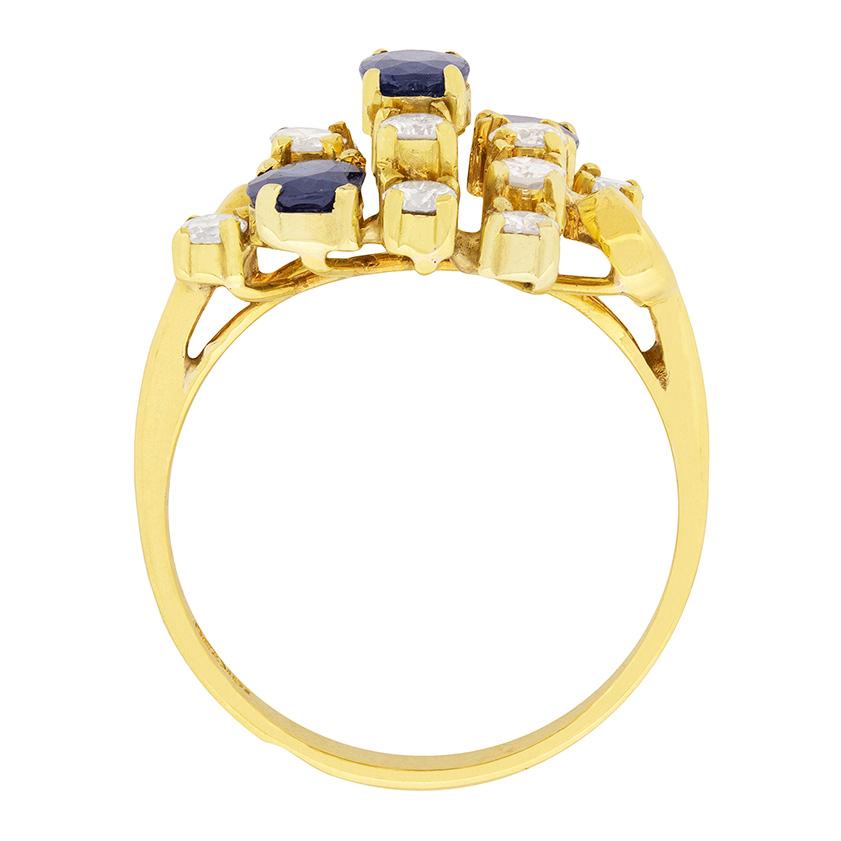 Dating to the 1980s, this vintage dress ring features three centre sapphires, oval in shape and claw set. Each stone weigh 0.40 carat and the surrounding 12 diamonds, each weigh 0.05 carat. The sparkling round brilliants are also claw set and have
