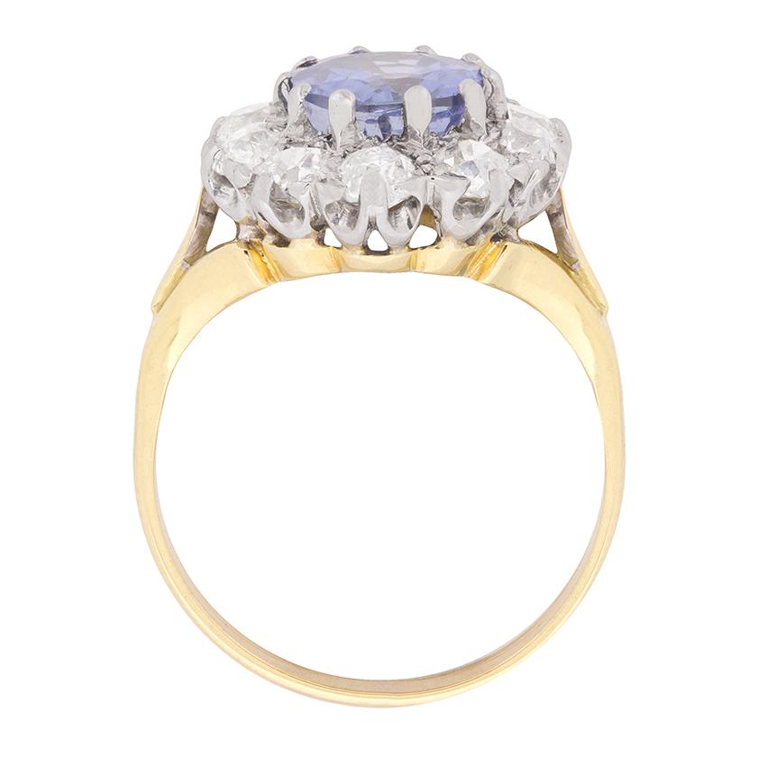 A beautiful sapphire and diamond cluster ring, with a 2.42 carat sapphire in the centre. It is a wonderful sea blue colour and oval in shape. It is surrounded by ten old cut diamonds, equalling a weight of 1.50 carat, making this a true statement